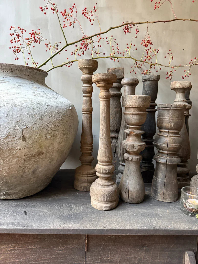 Handgemaakte houten balusters en sobere vaas op houten tafel, landelijk interieurdecor.