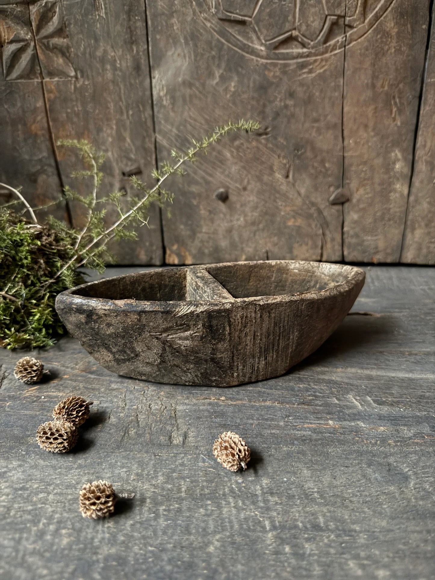 Authentiek handgemaakt houten bakje met vakken op een rustieke houten tafel, landelijk interieur