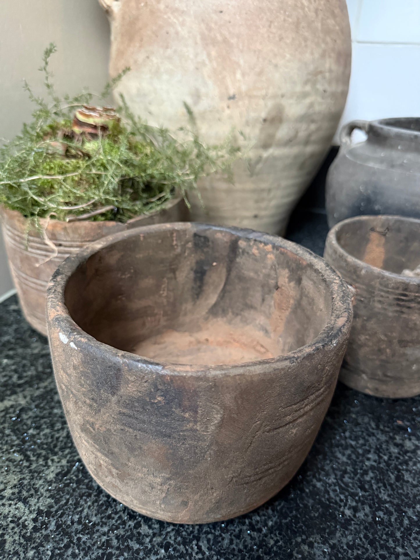 Handgemaakte sobere aardewerken potten en vaas op een donkere ondergrond, My Sober Home stijl