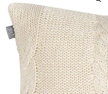 Close-up van een handgemaakt, gebreid roomkleurig kussen bij My Sober Home.