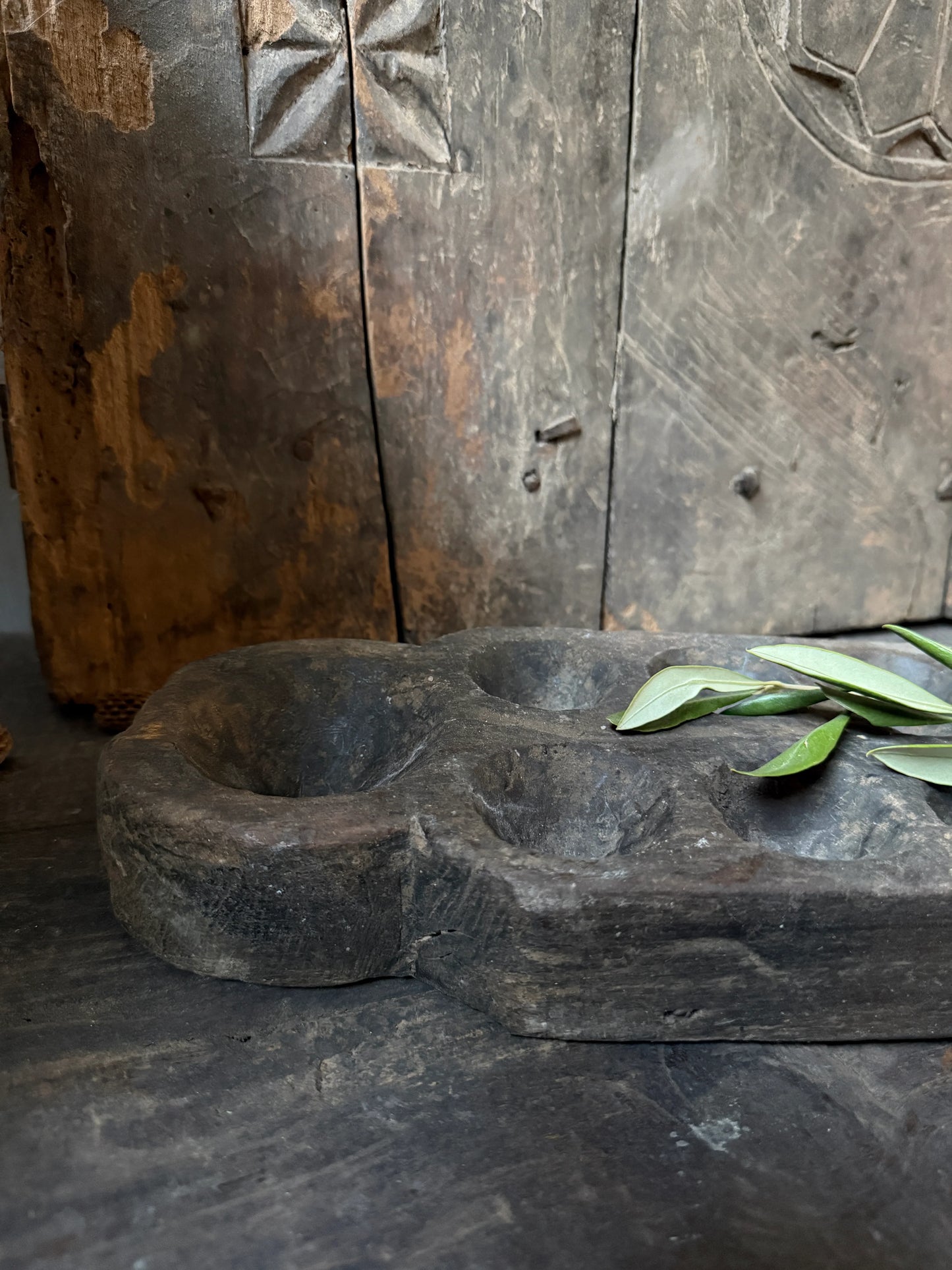 Authentieke landelijke Indiase houten schaal op rustieke tafel, handgemaakt woonaccessoire.