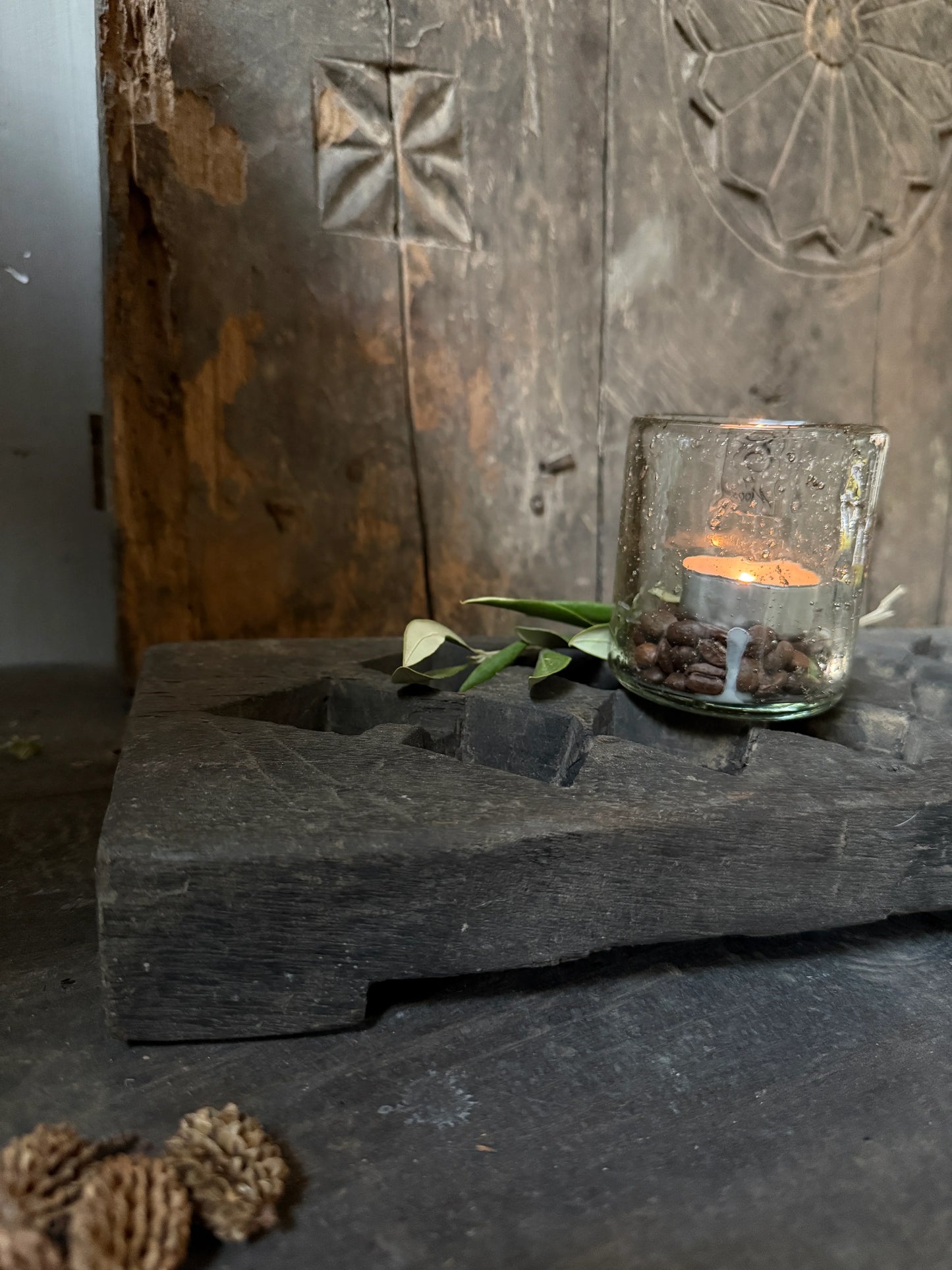Handgemaakt houten plateau met rustieke theelichthouder in sober landelijk interieur