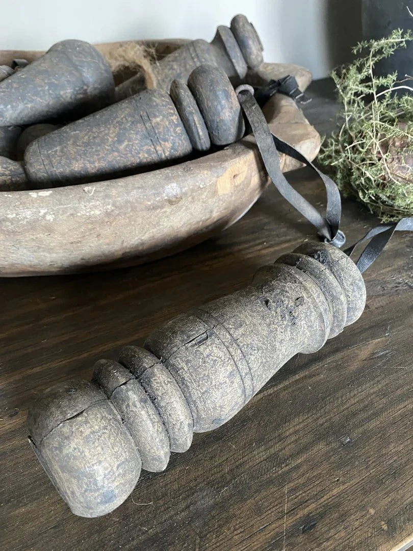 Authentieke oude houten klos als landelijke woonaccessoire op donkere houten tafel