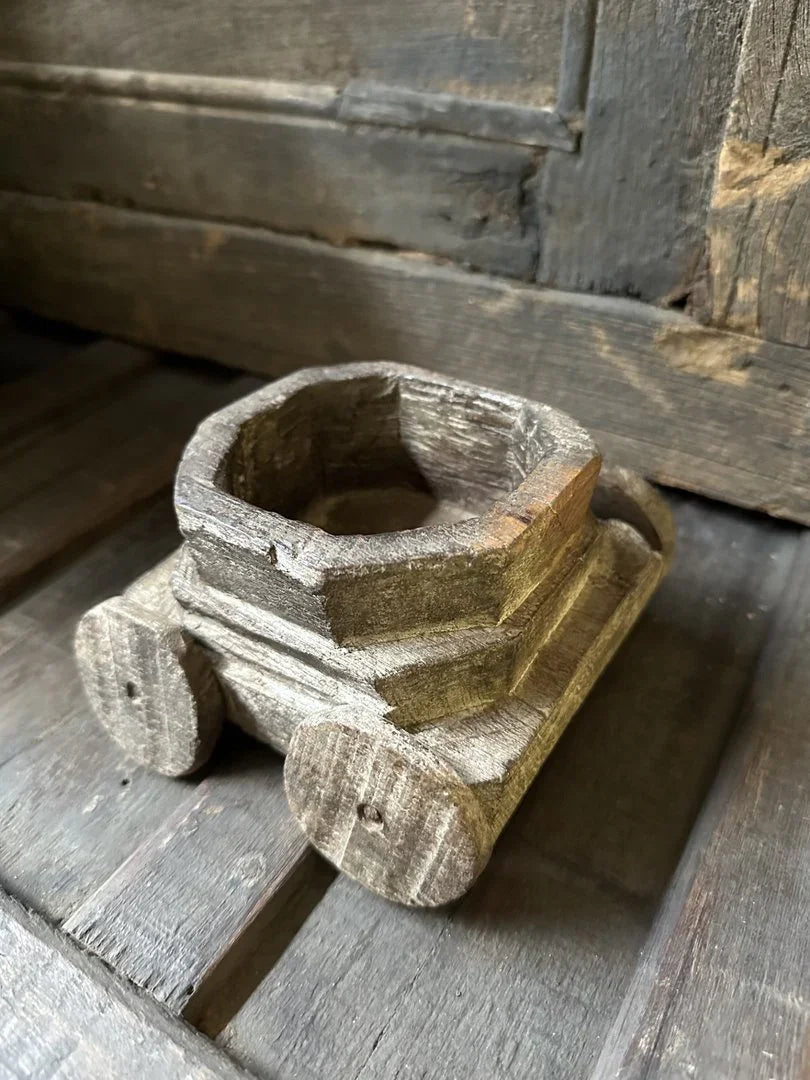 Authentiek handgemaakt houten speelgoedwagentje op landelijke houten ondergrond, sober interieur