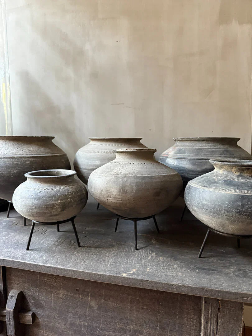 Authentieke handgemaakte tuimelkruikjes op houten kast, sober landelijk interieur