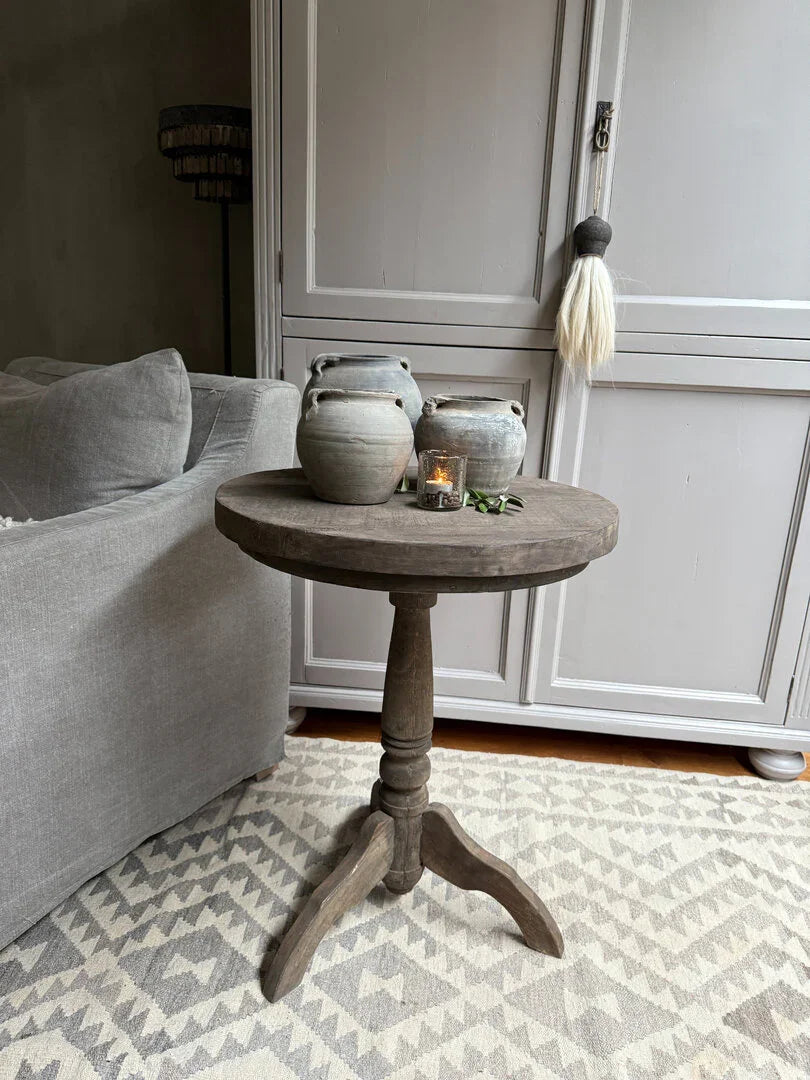 Ronde, houten wijntafel met sobere kruiken en kaars, landelijk sober interieur My Sober Home