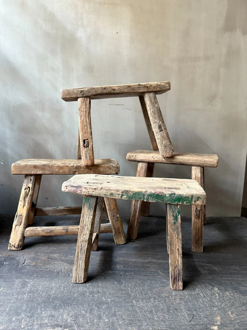 Drie authentieke, handgemaakte houten krukjes voor een sober, landelijk interieur.