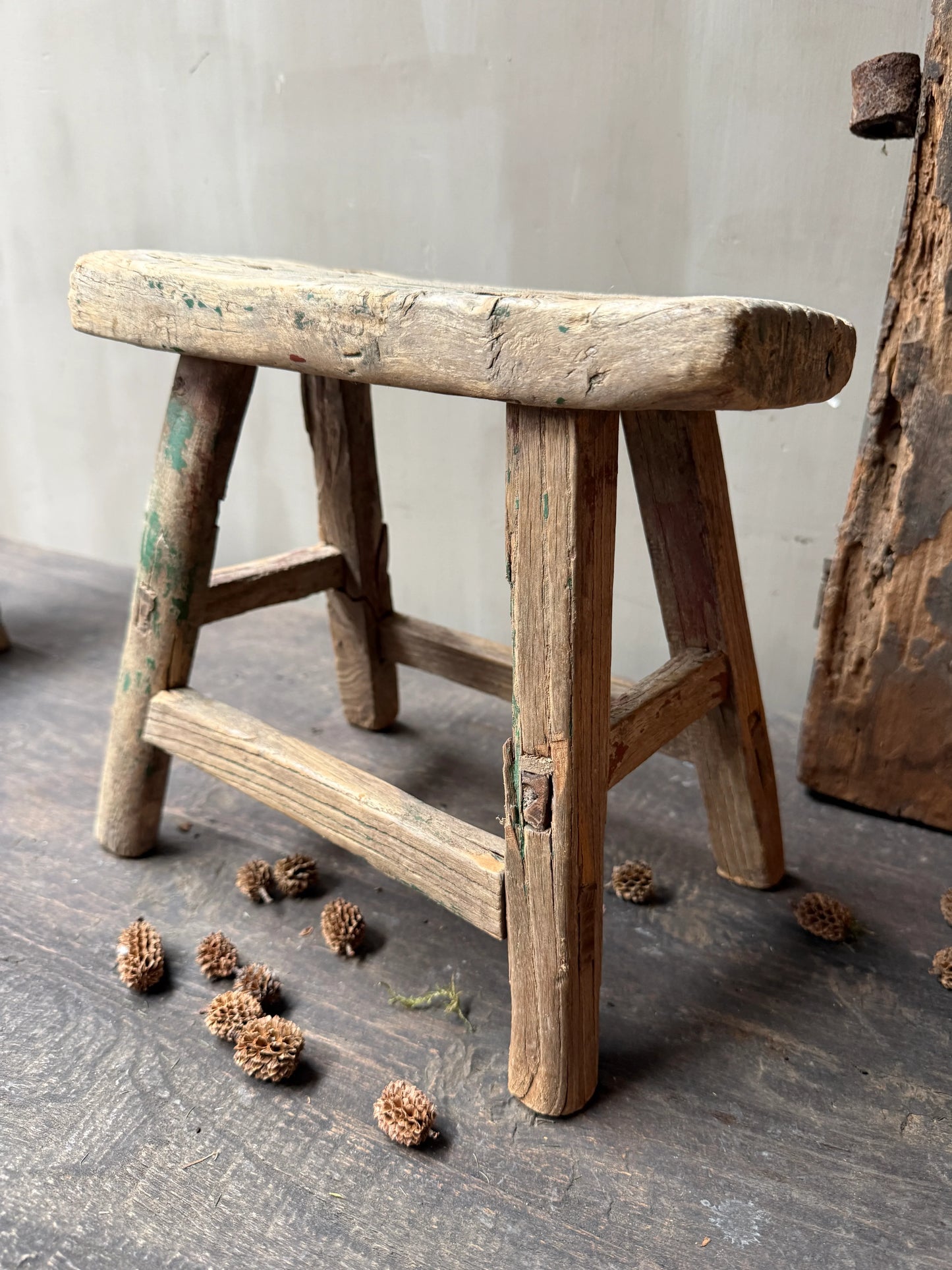 Authentiek handgemaakt houten krukje op houten vloer, landelijk en sober interieuraccessoire.