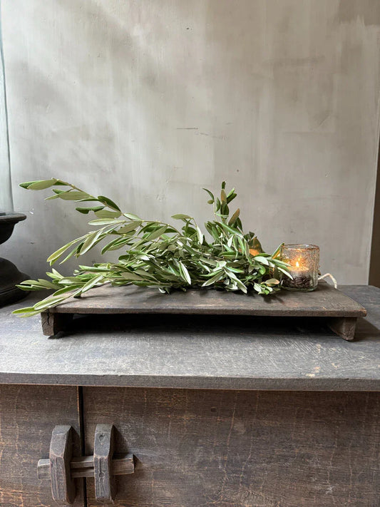 Authentiek houten bajot plateau met groene tak en glazen windlicht, landelijk sober interieur