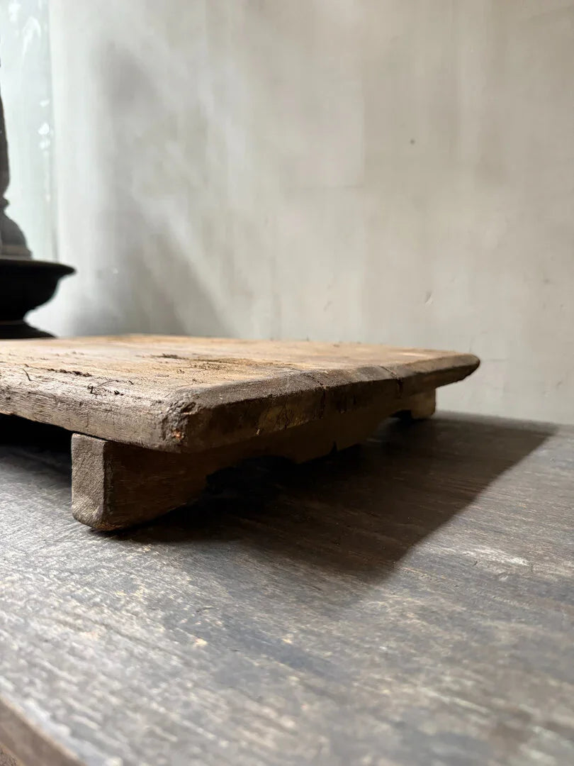 Authentiek houten Bajot tafeltje op donkere tafel, sober en landelijk woonaccessoire