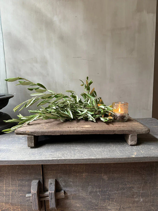 Authentieke houten Bajot met groene tak en sfeervol kaarsje, landelijk sober interieur