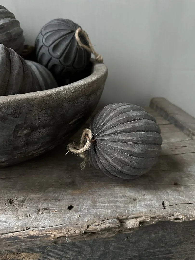 Handgemaakte sobere grijze ballen als woonaccessoires in landelijke houten schaal