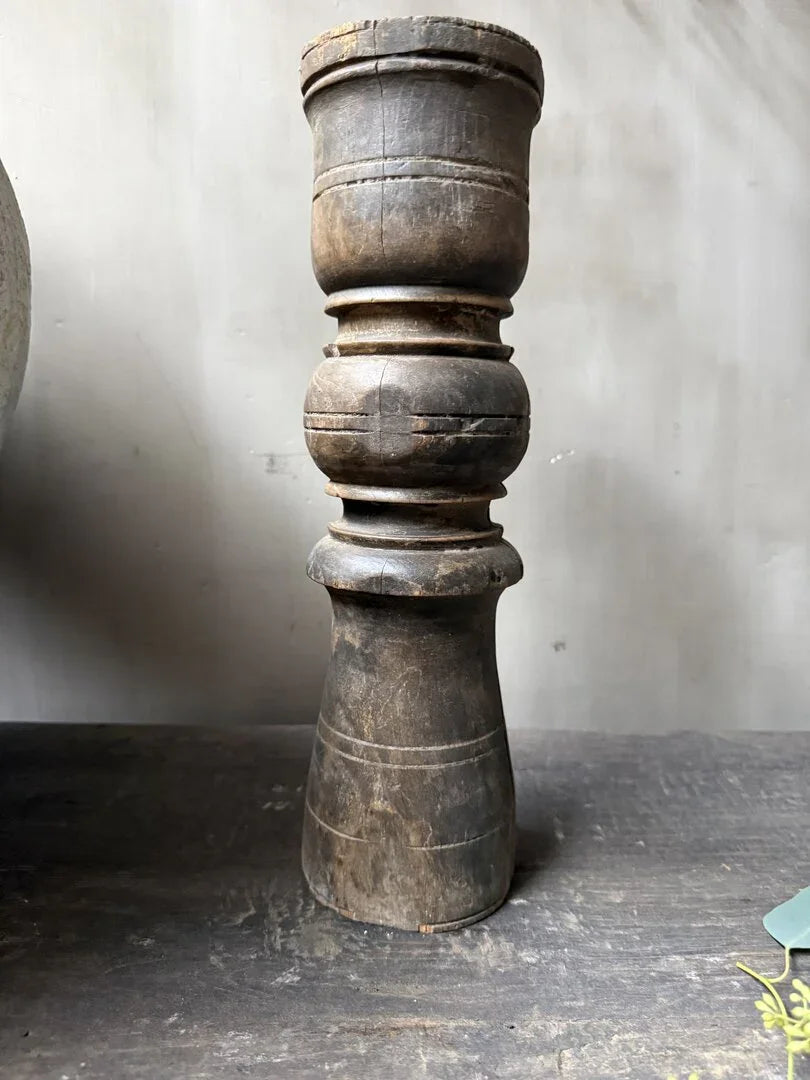 Authentieke handgemaakte houten baluster, sobere landelijke woonaccessoire op donkere ondergrond