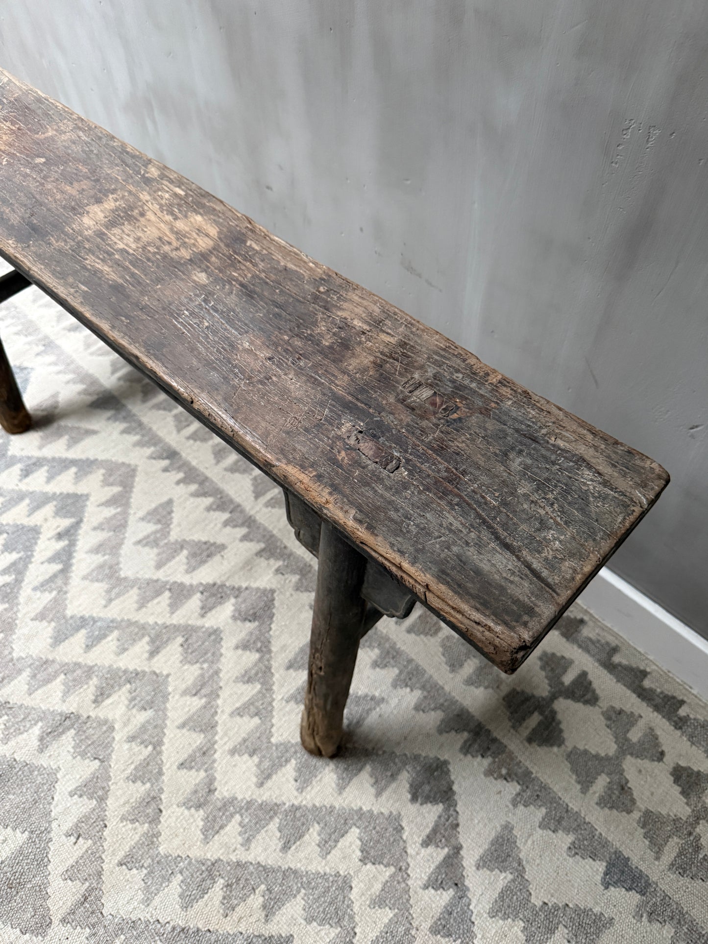 Authentiek, handgemaakt houten bankje met verweerde look op lichtgrijs vloerkleed, My Sober Home