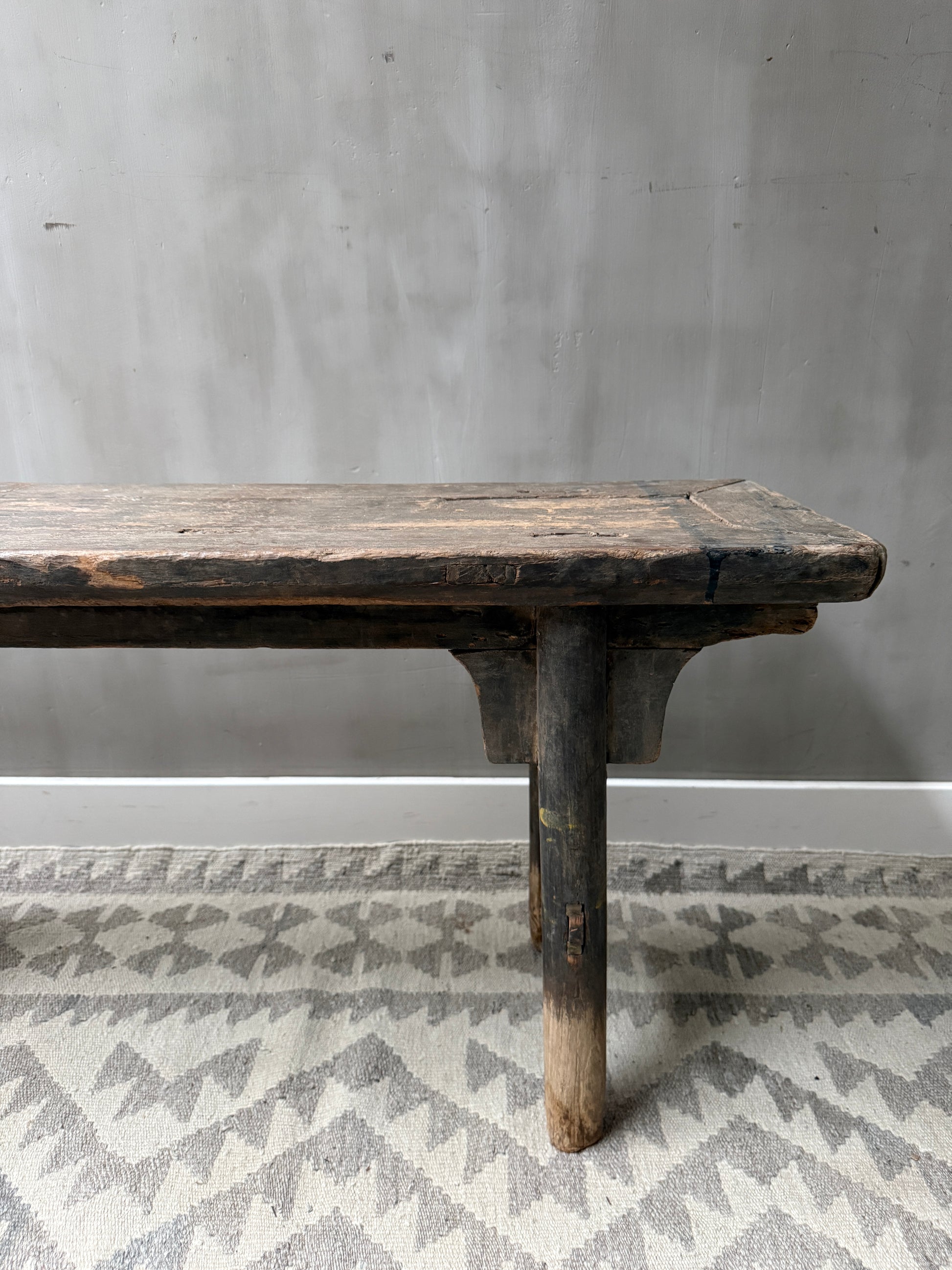 Authentiek, handgemaakt houten bankje op vintage vloerkleed, landelijk sober interieur