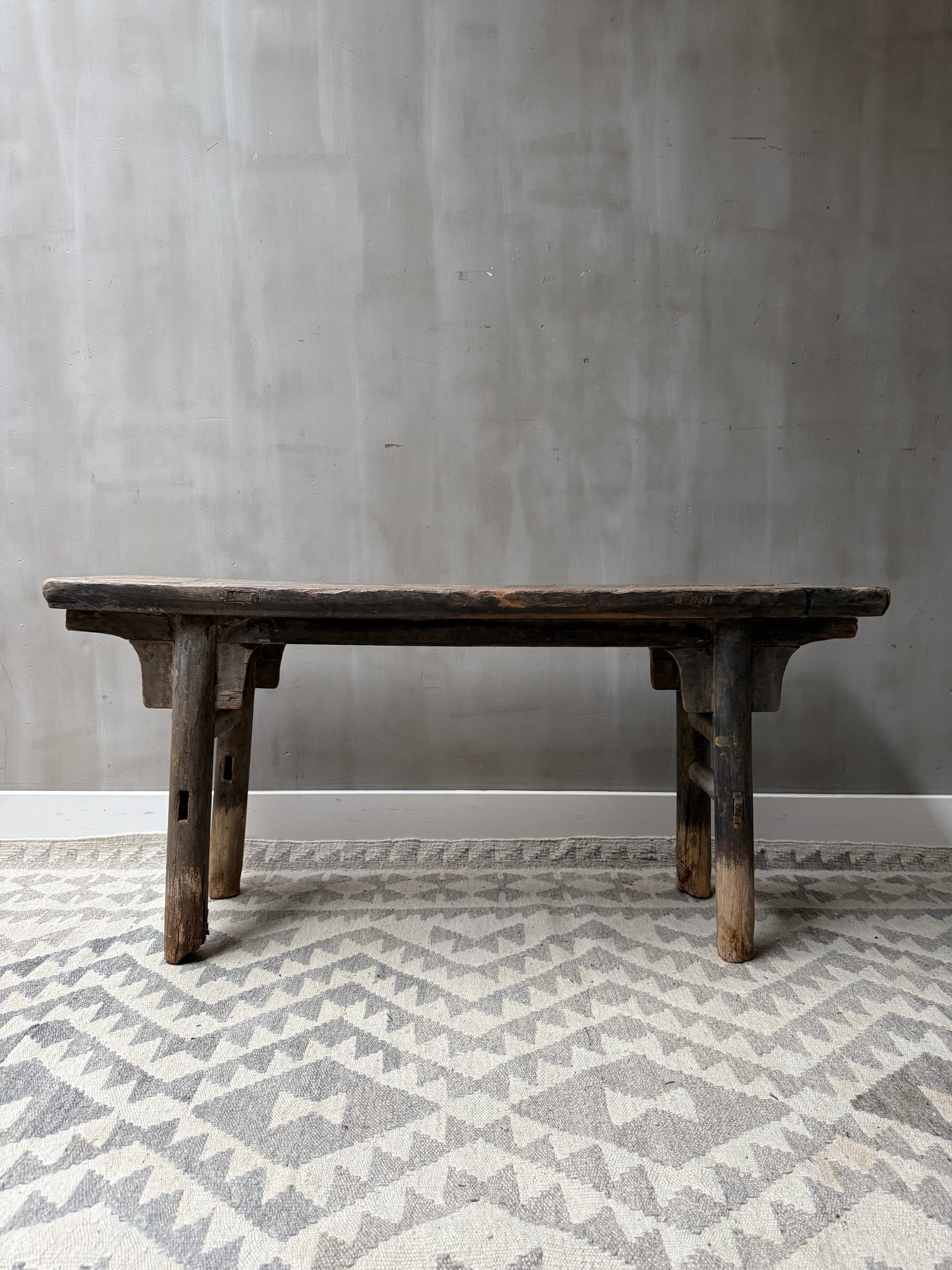 Authentiek handgemaakt houten bankje op traditioneel vloerkleed, sober interieur My Sober Home