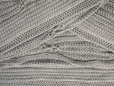 Close-up van een handgemaakt, grofgebreid Barcelona woonaccessoire in duifgrijs, My Sober Home