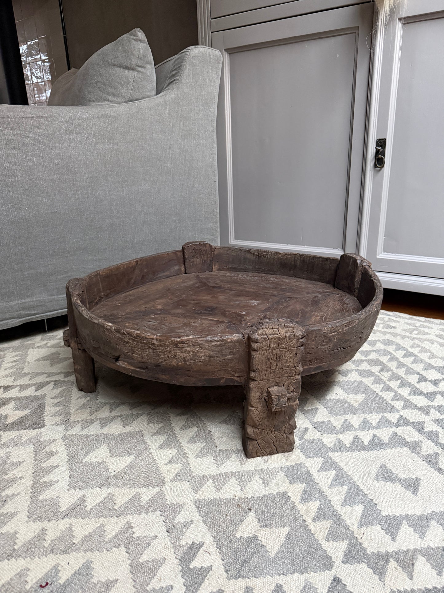 Handgemaakte houten chakkitafel op licht kleed, landelijk sober interieur