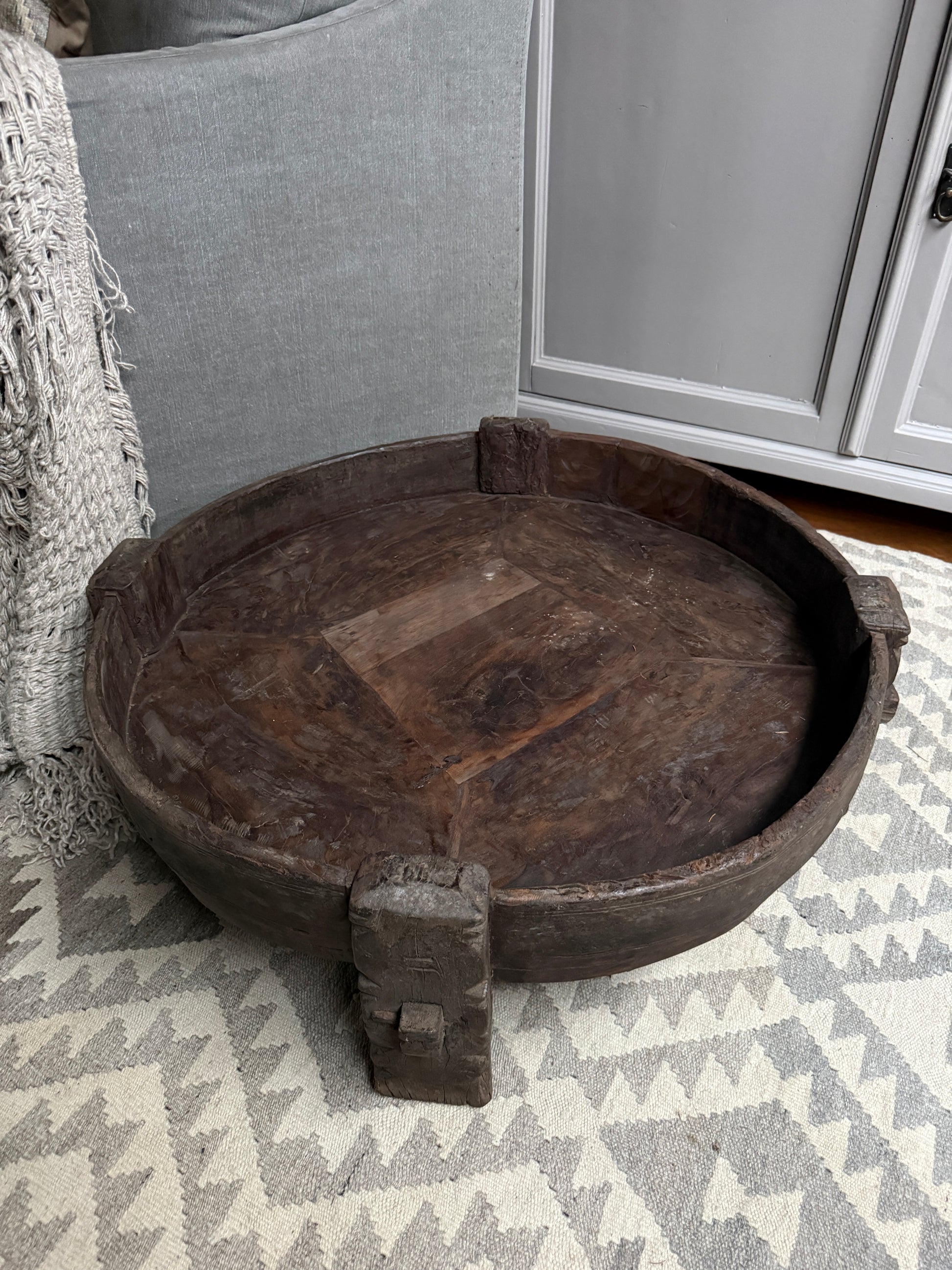 Authentieke, handgemaakte chakkitafel van hout in sober, landelijk interieur op vloerkleed