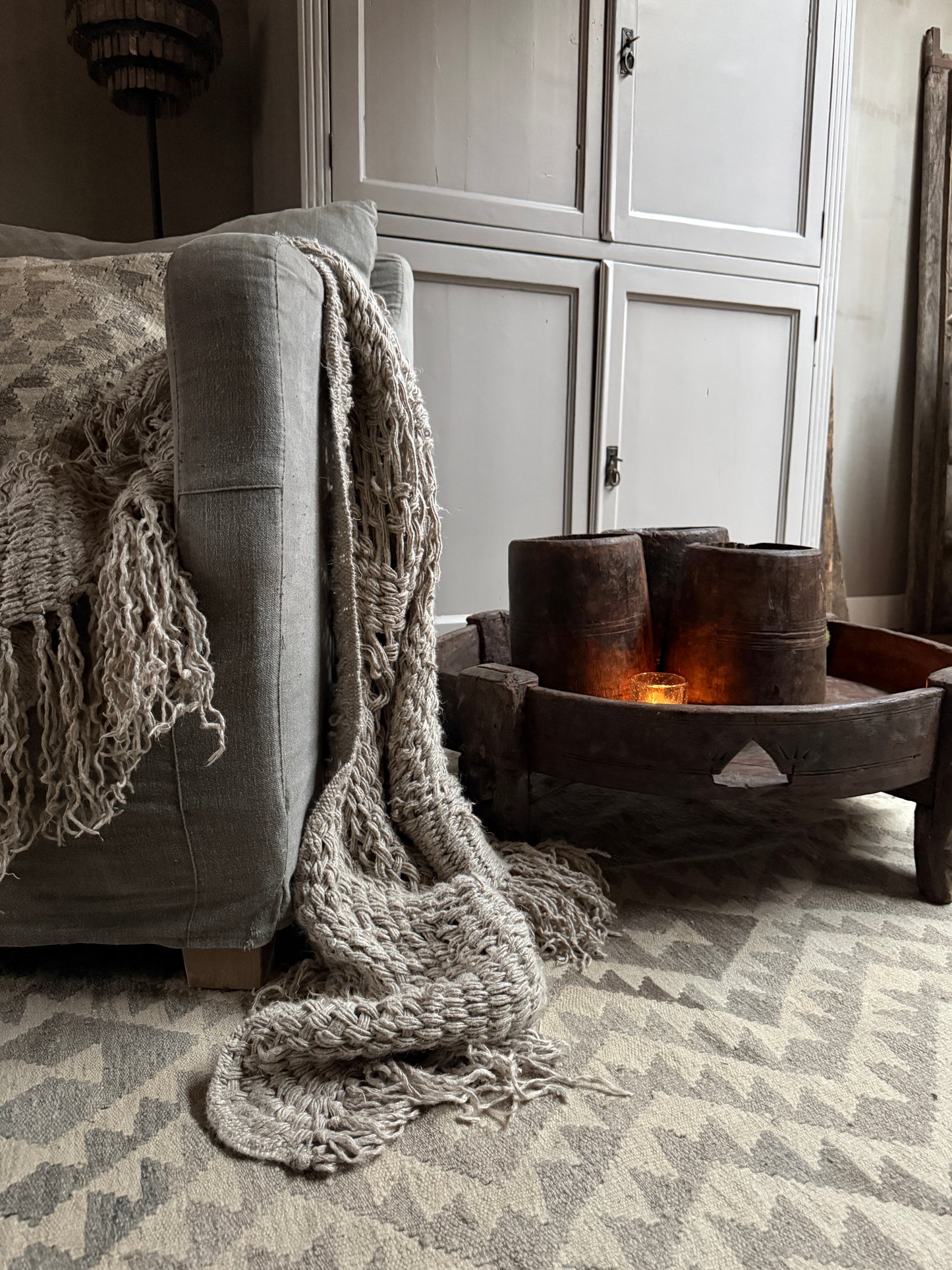 Landelijk interieur met handgemaakte plaid op bank, houten schaal en sfeervolle kaars, My Sober Home.