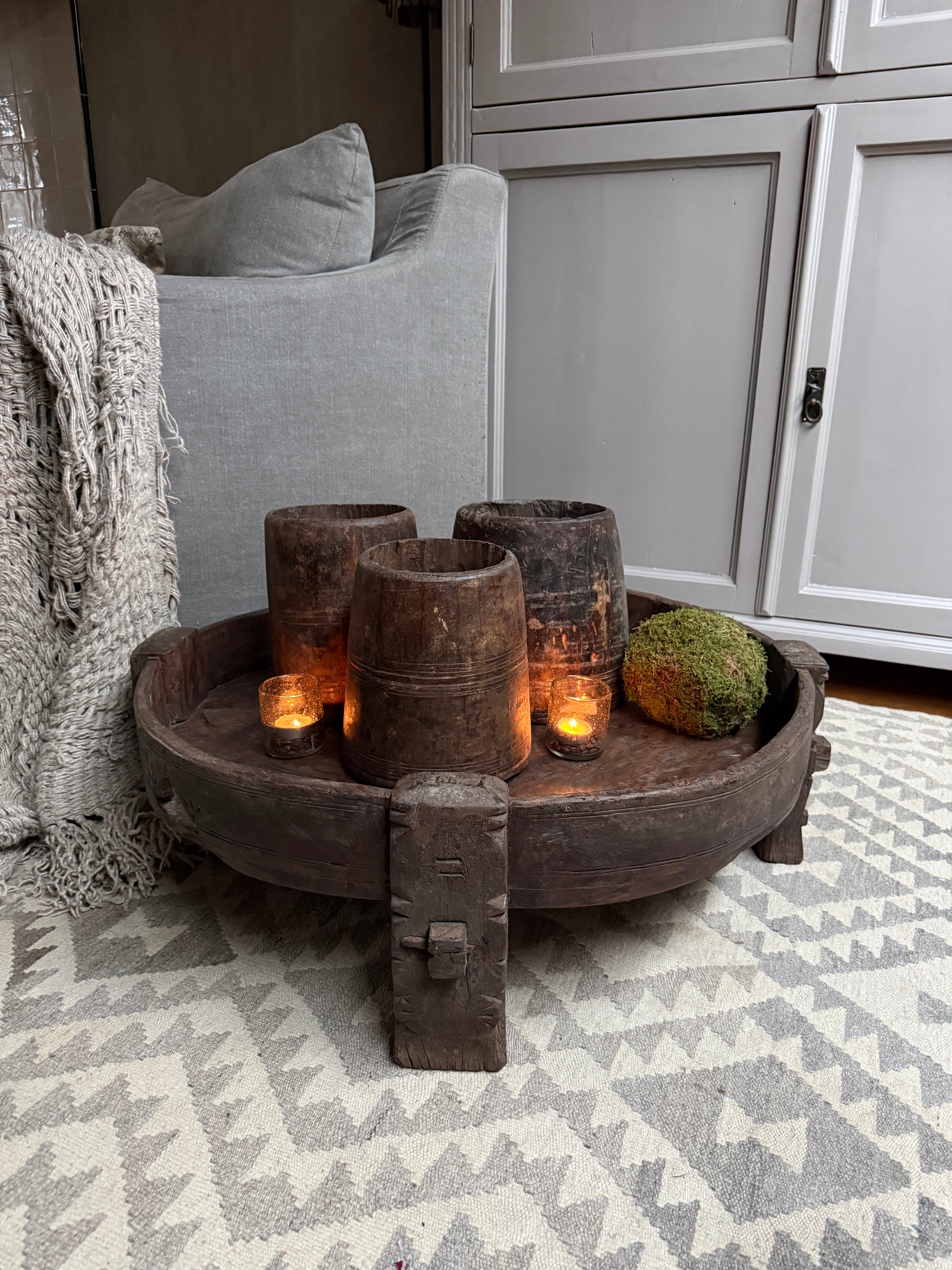 Authentiek houten chakkitafeltje met kaarsen en decoratie in sober, landelijk interieur