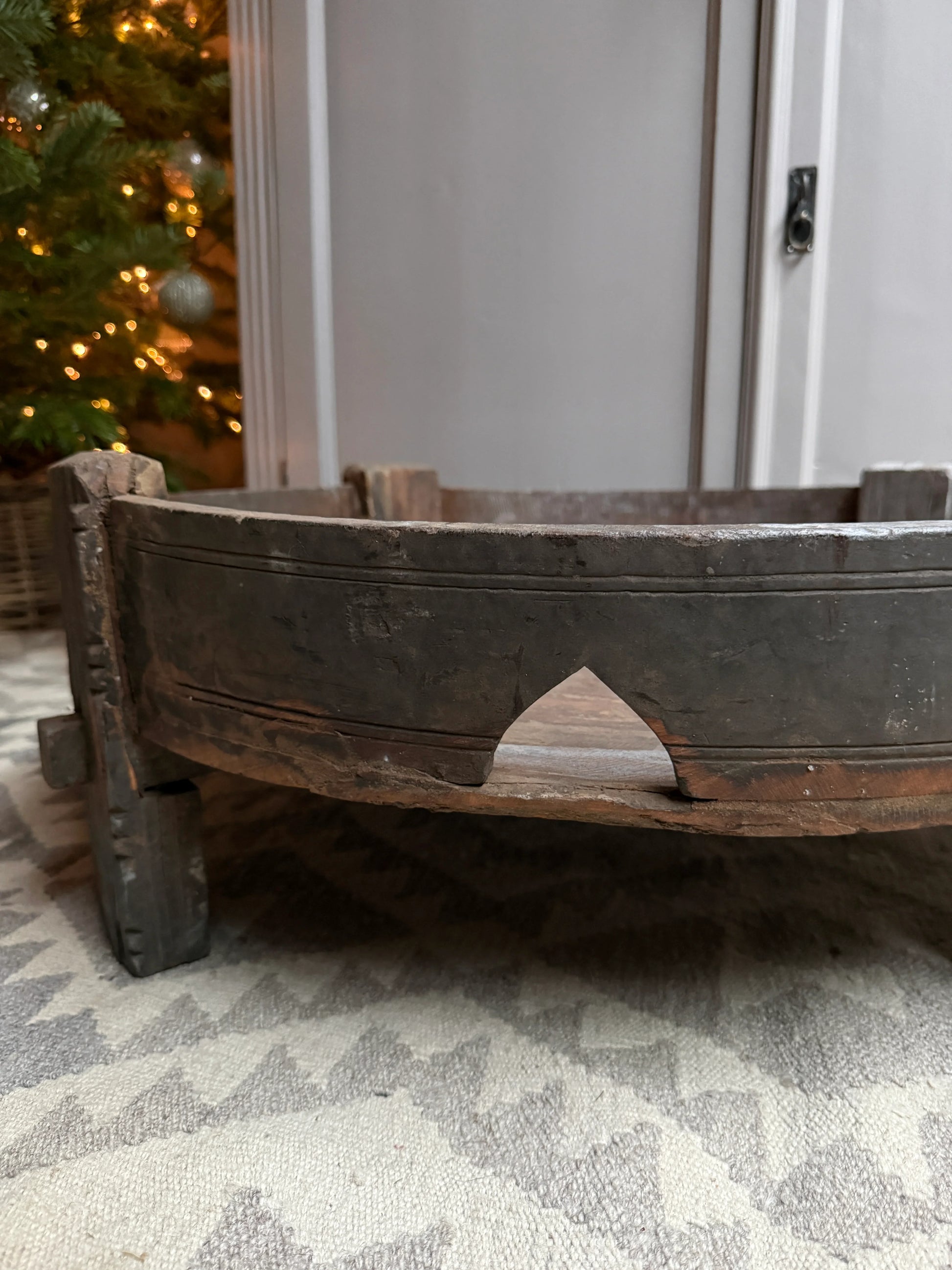 Authentieke handgemaakte houten chakki tafel uit India op vloerkleed, landelijke sfeer