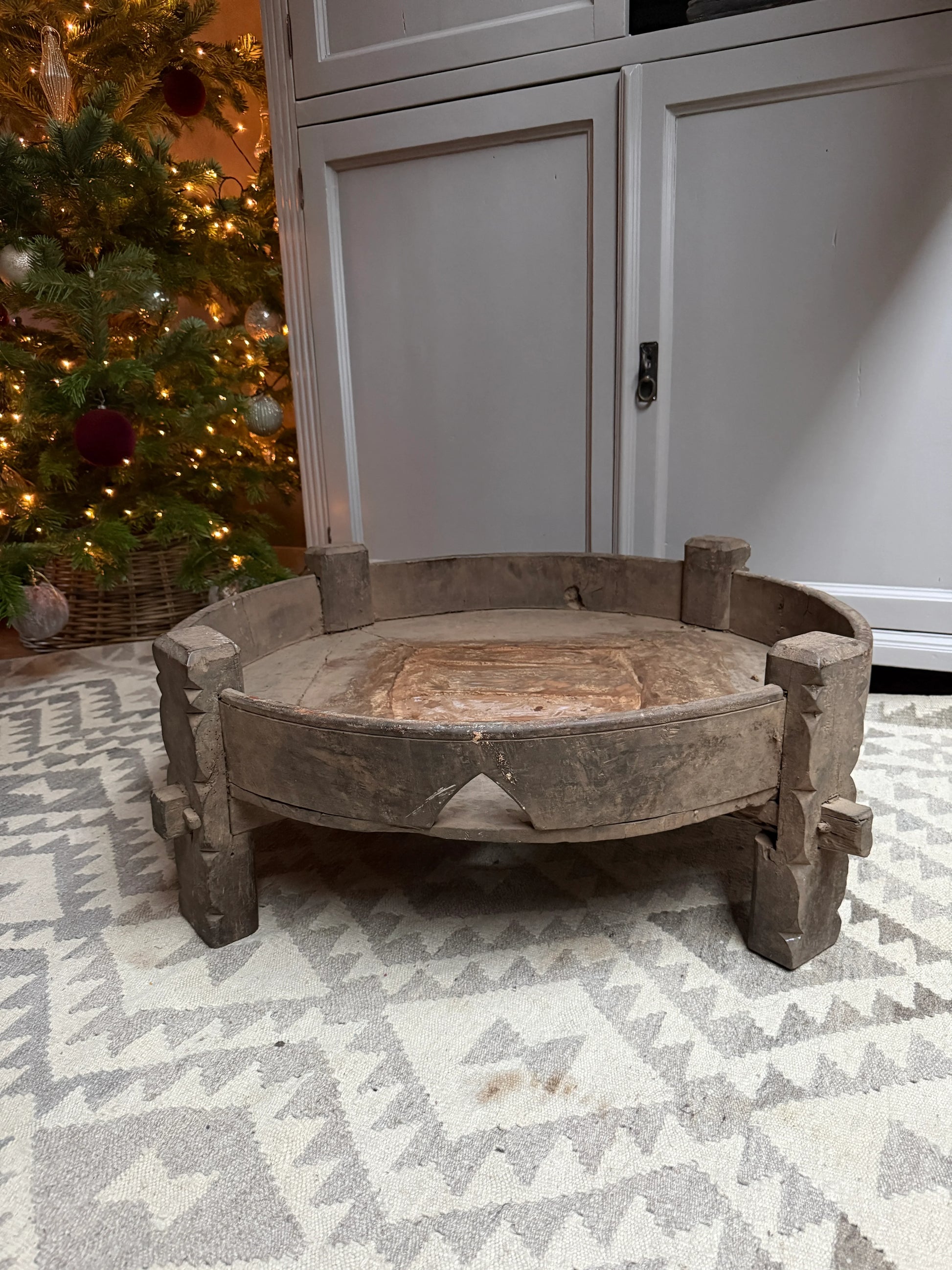 Oude houten chakkitafel uit India op oosters vloerkleed, landelijke woonaccessoire