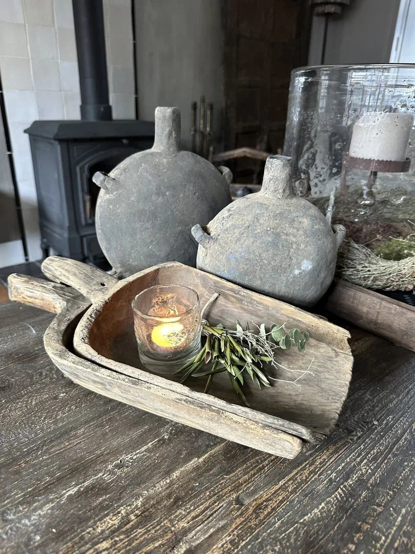 Authentieke Chinese oliefles, houten schaal en sfeervol kaarsje op een landelijke houten tafel, sober interieur