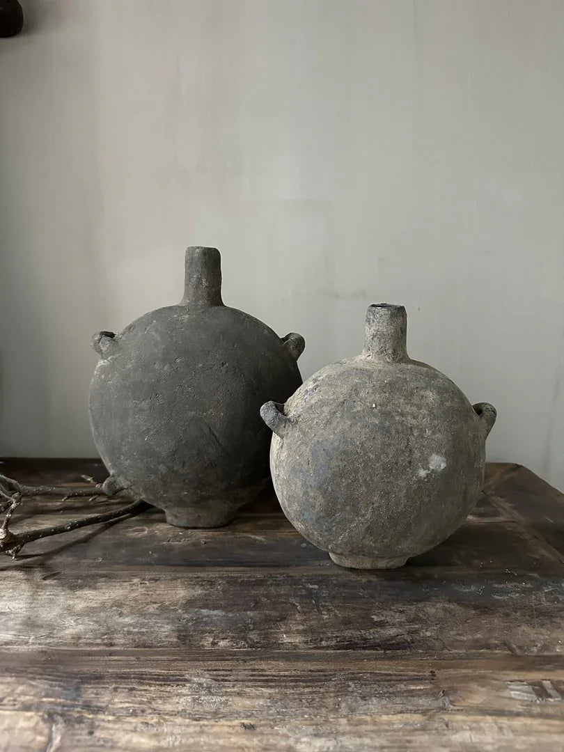 Twee authentieke, handgemaakte Chinese olieflessen van aardewerk op een houten tafel, sober interieur