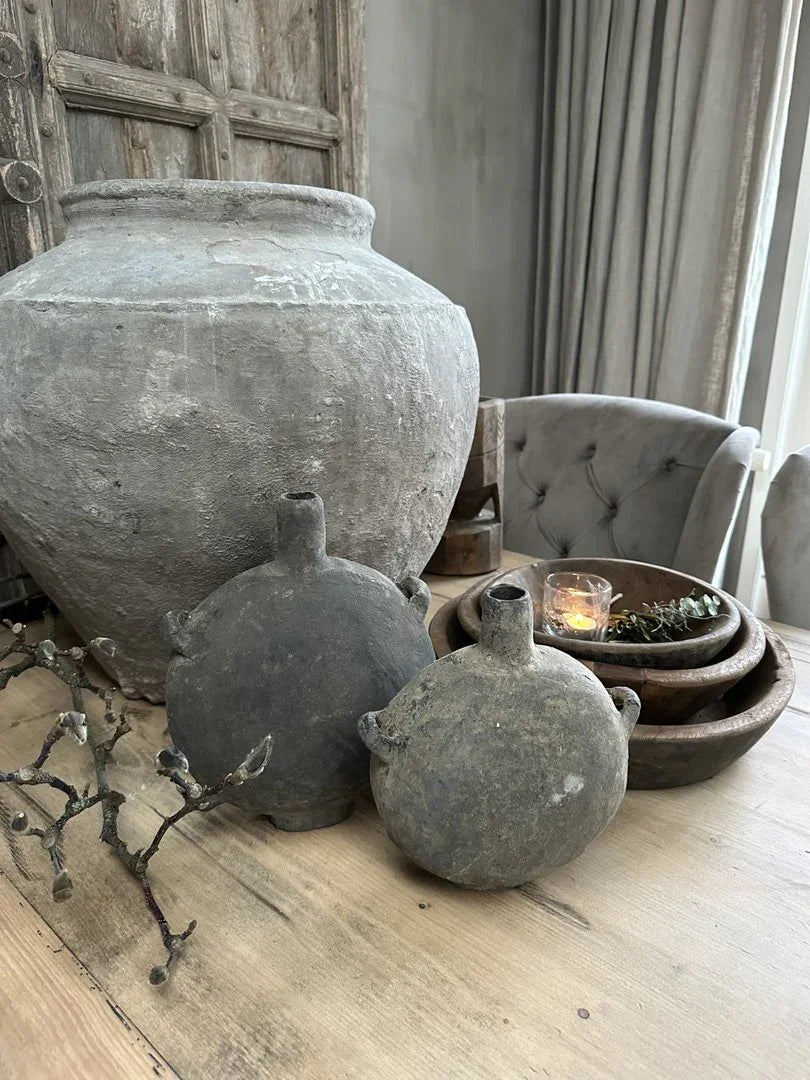 Authentieke Chinese olieflessen en pot op houten tafel, sober landelijk interieur