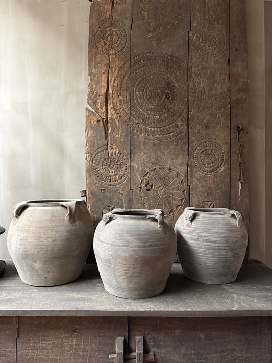 Authentieke handgemaakte Chinese kruiken op houten kast, sober landelijk interieur