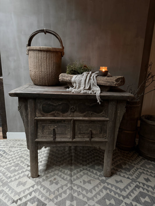 Sober Chinese wandtafel met houten mand, decoratie en brandende kaars in landelijk interieur