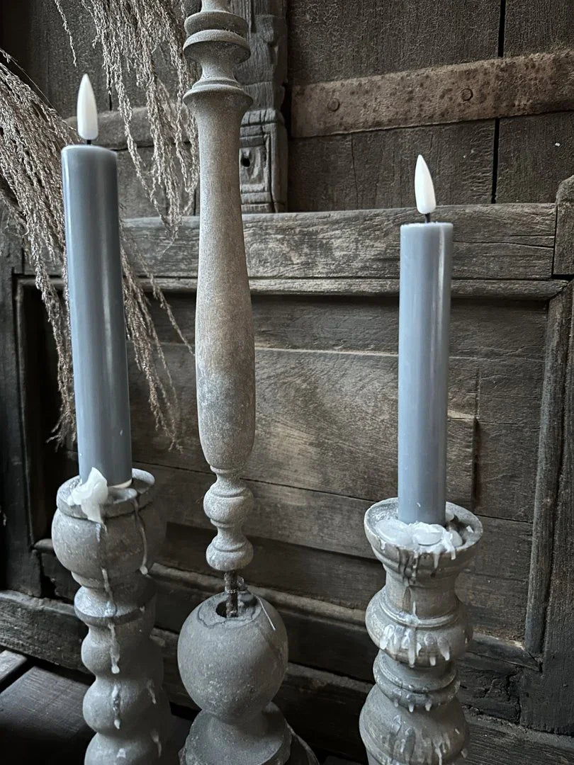 Grijze dinerkaarsen in rustieke kandelaren, sfeervol landelijk interieuraccessoire.