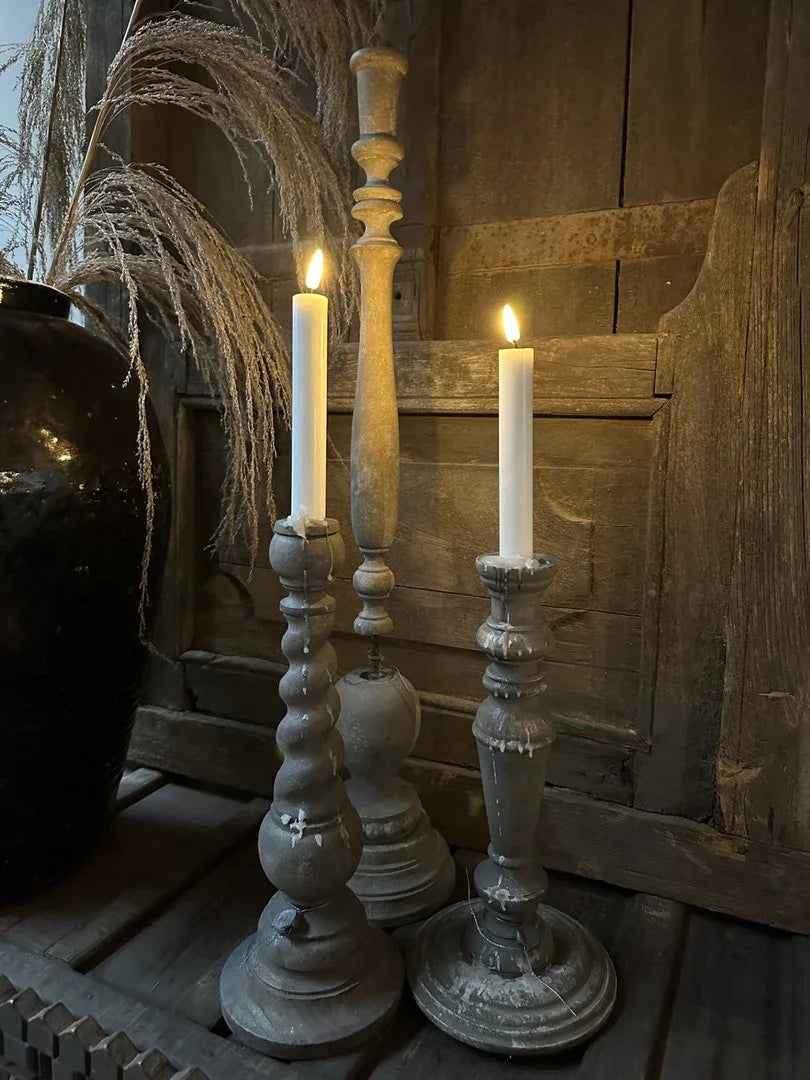 Landelijke sobere woondecoratie met handgemaakte houten kandelaars en brandende kaarsen