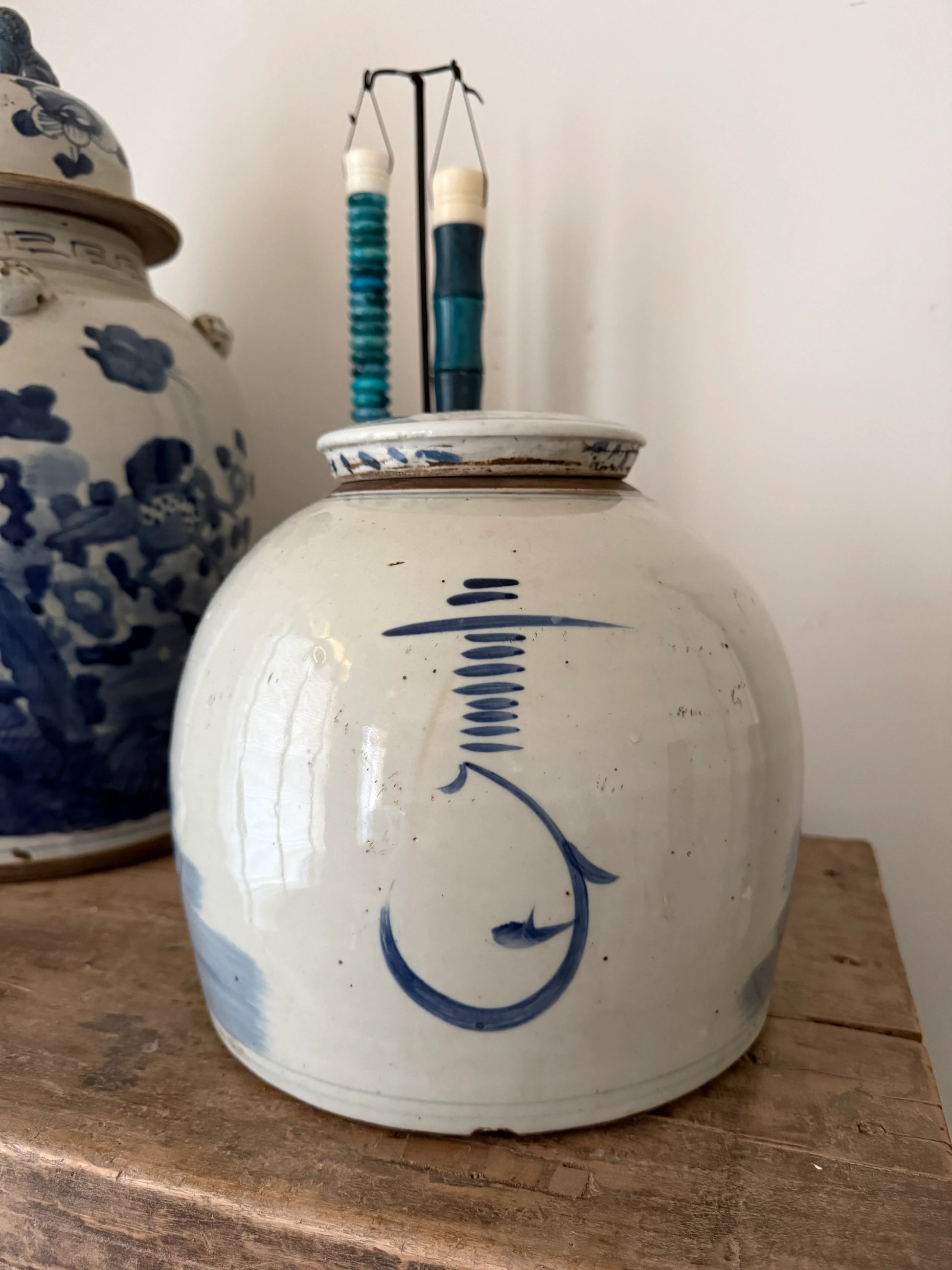 Handgemaakte blauwe en witte gemberpot op houten tafel, sober landelijk interieur