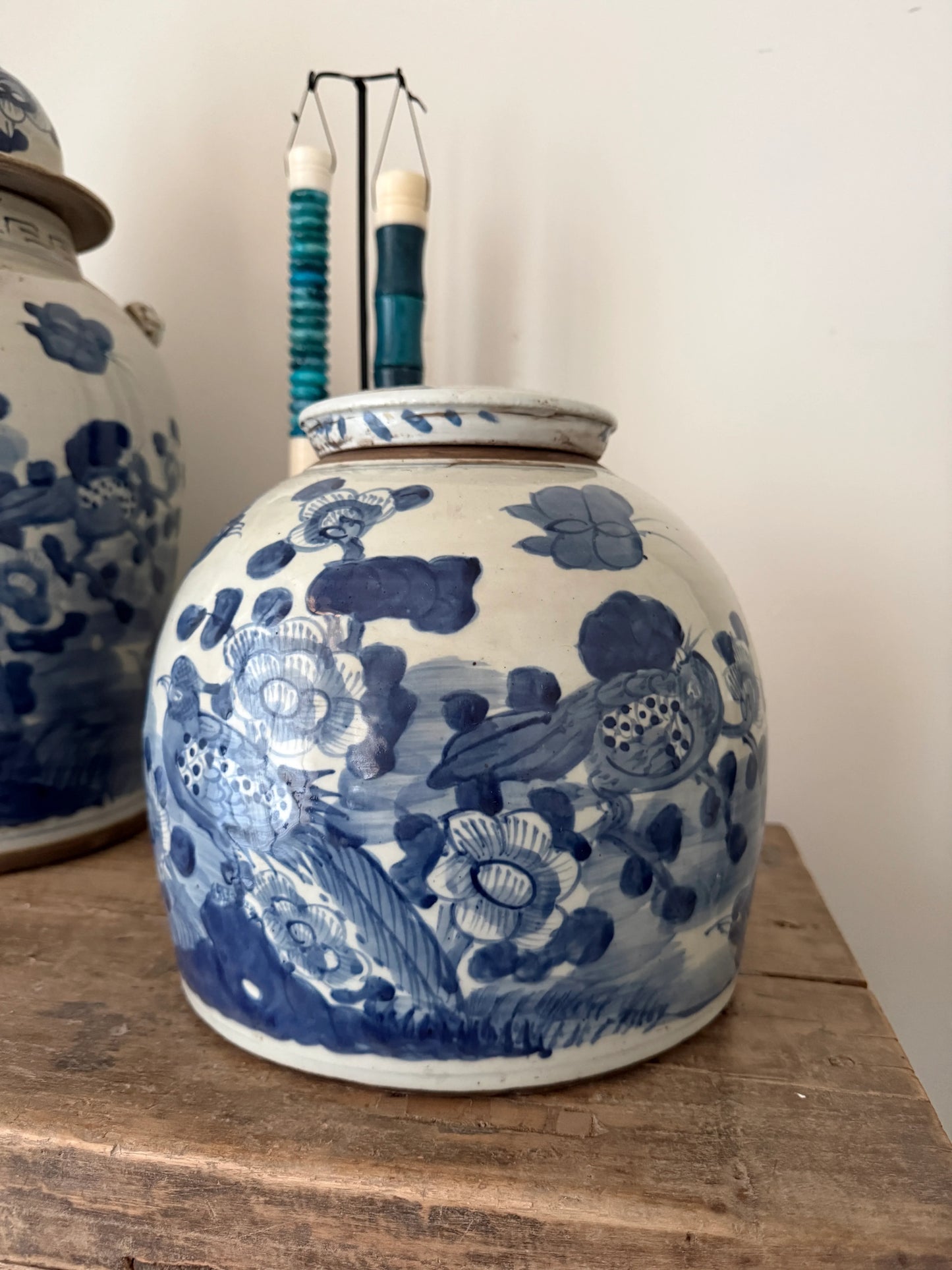 Handgemaakte blauwe gemberpot met bloemenmotief op houten tafel, landelijk en sober interieur