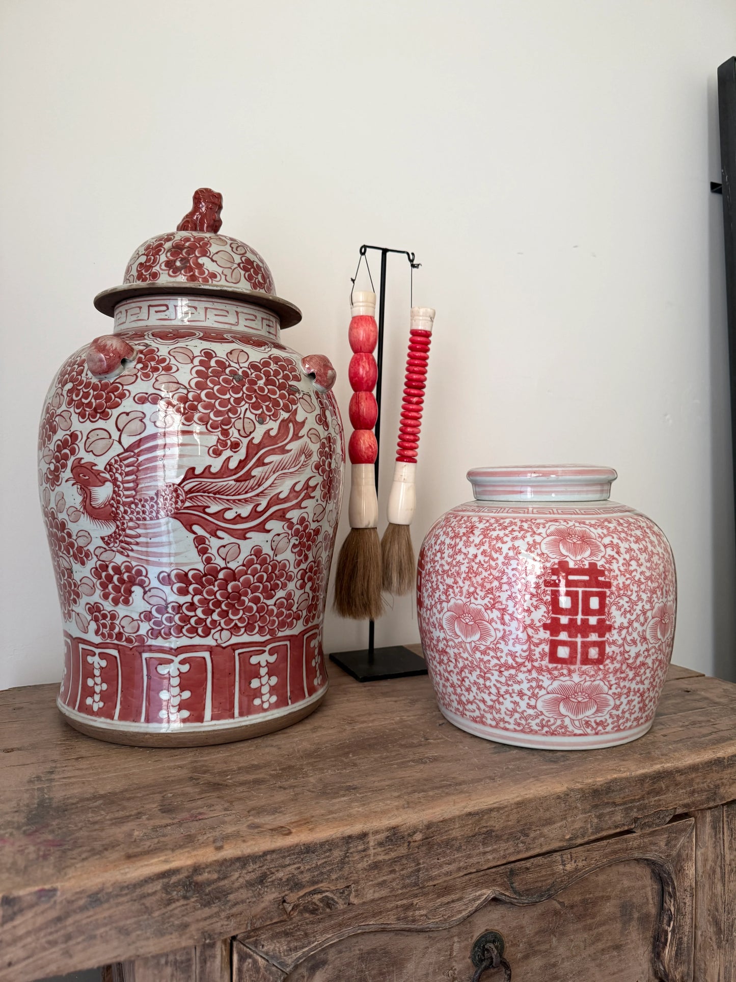 Twee handgemaakte gemberpotten met roze decor op houten kast, landelijke woonaccessoire