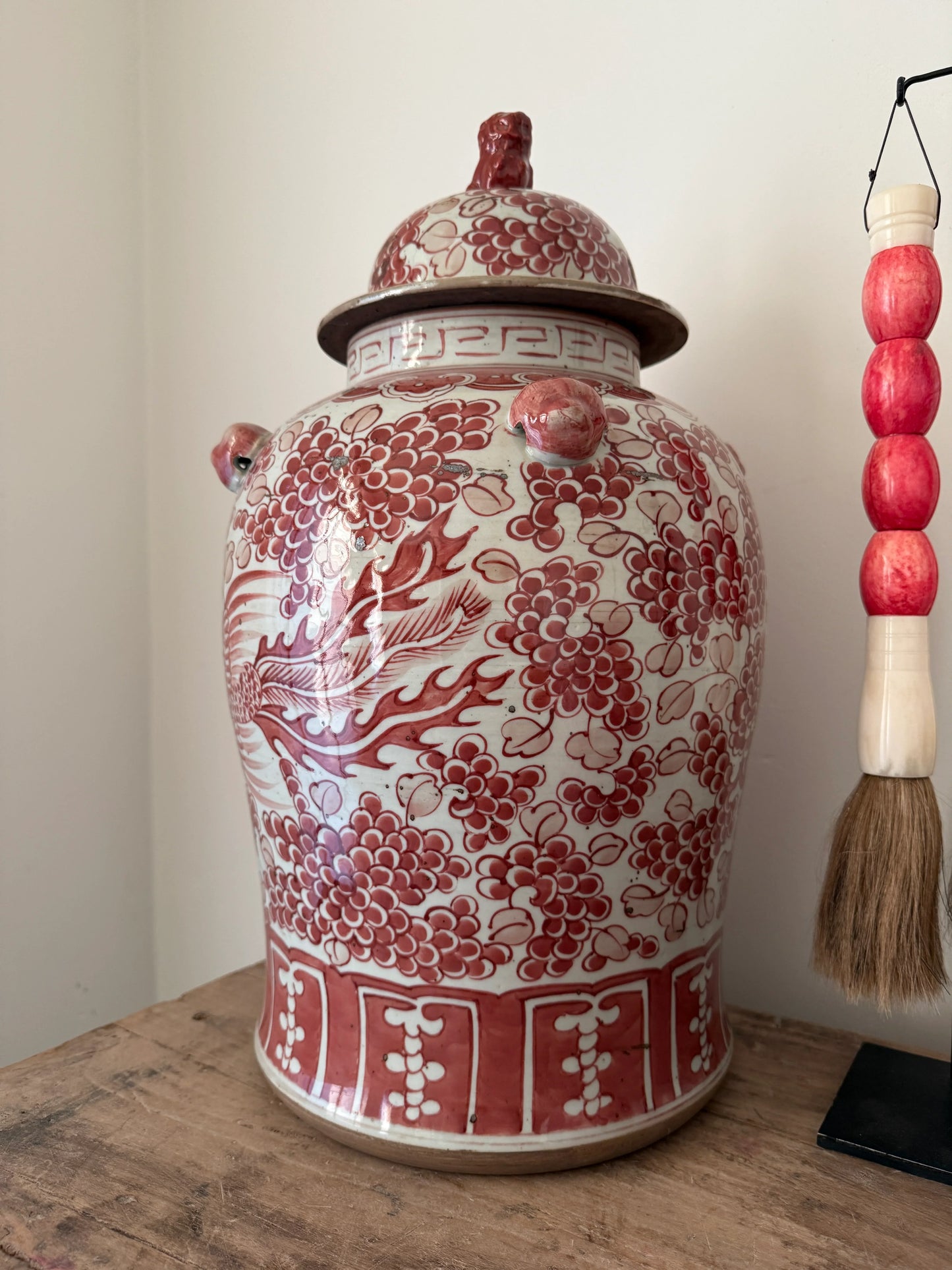 Authentieke handgemaakte gemberpot met rood bloemenmotief, oosters woonaccessoire op houten tafel