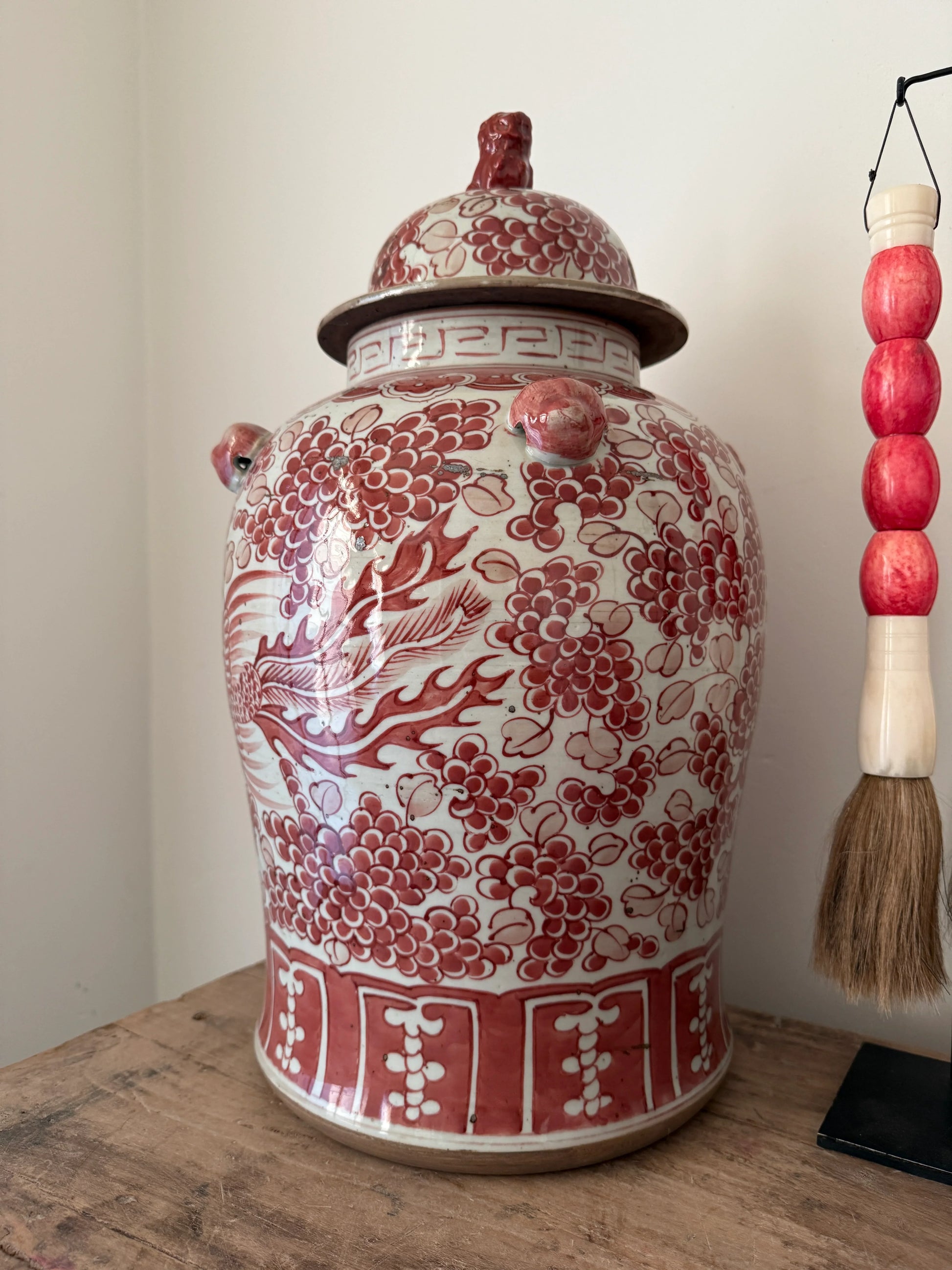 Authentieke handgemaakte gemberpot met rood bloemenmotief, oosters woonaccessoire op houten tafel