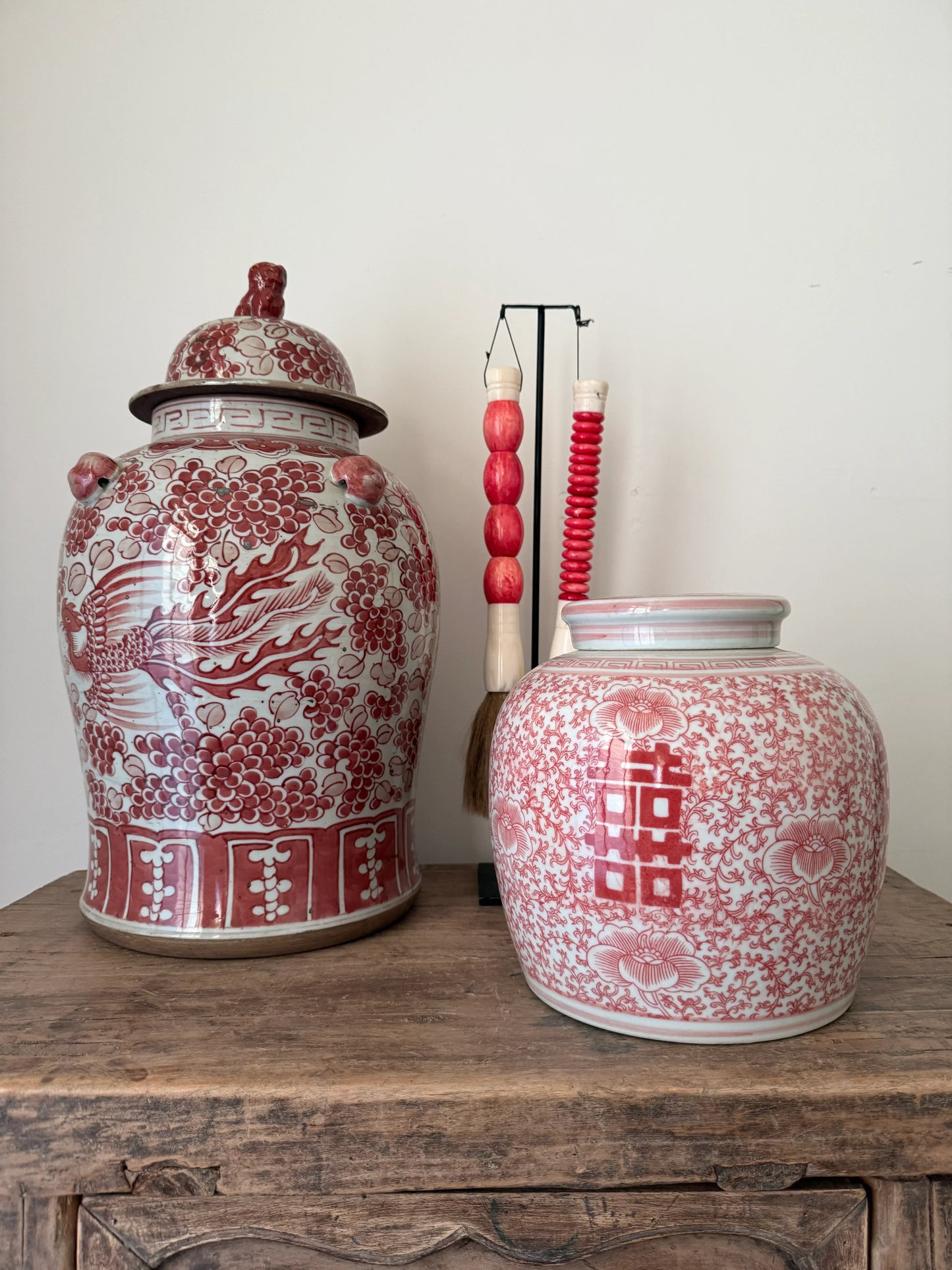 Handgemaakte oosterse gemberpotten met rood-wit patroon op houten tafel, landelijk interieur