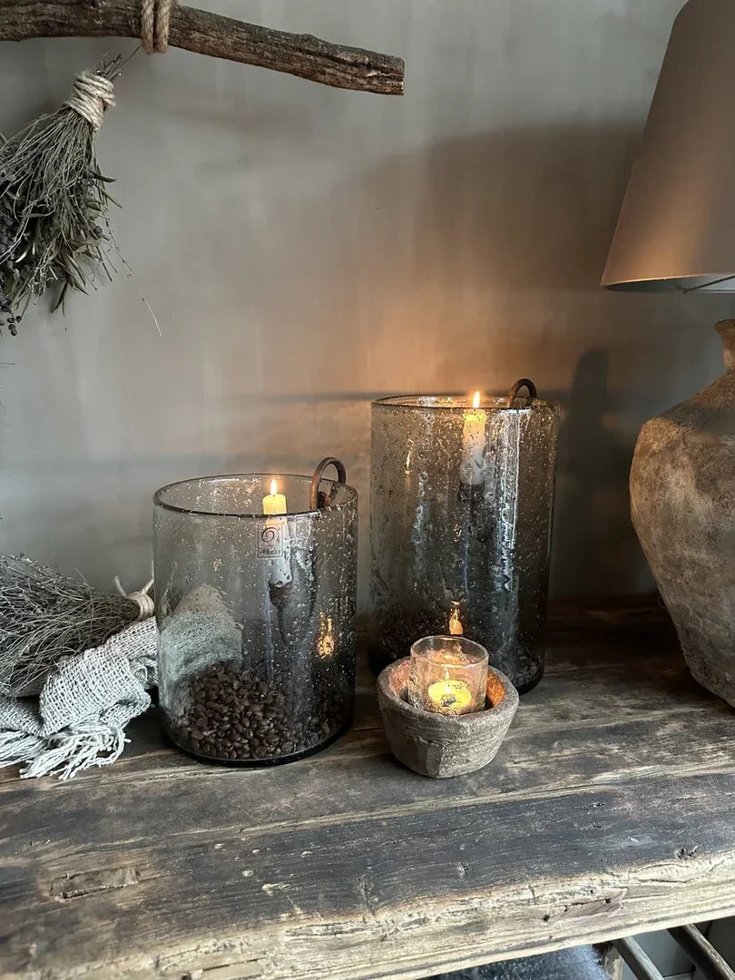 Sereen landelijk interieur met handgemaakte glazen windlichten, kaarsen en houten accessoires