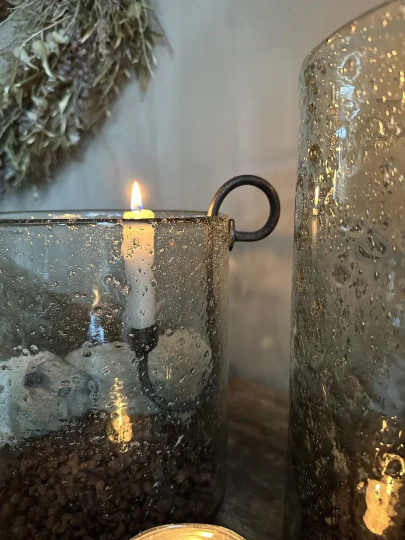 Handgemaakte glazen windlicht met zwarte ijzeren glashaak, landelijke sobere woondecoratie.