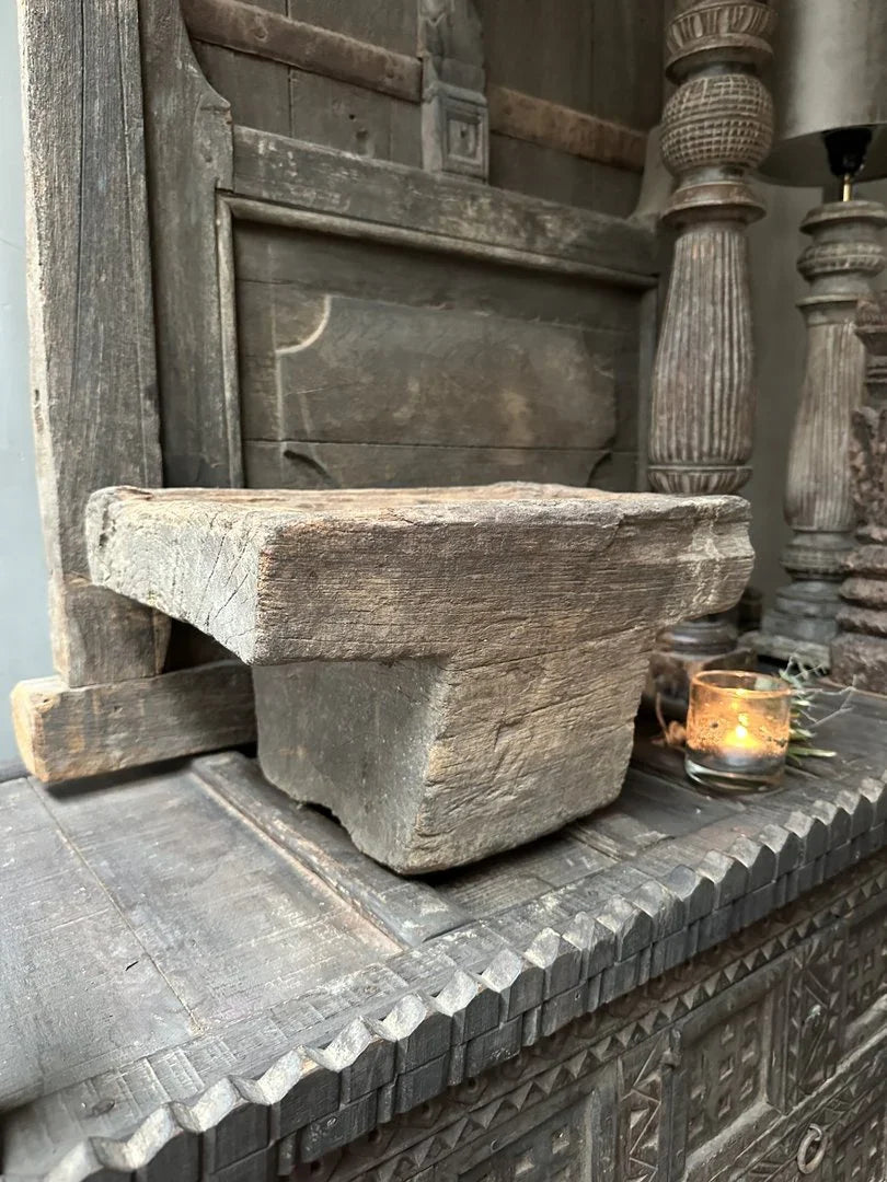 Grote oude houten poer op landelijke kast, sobere woonaccessoire met brandend waxinelichtje