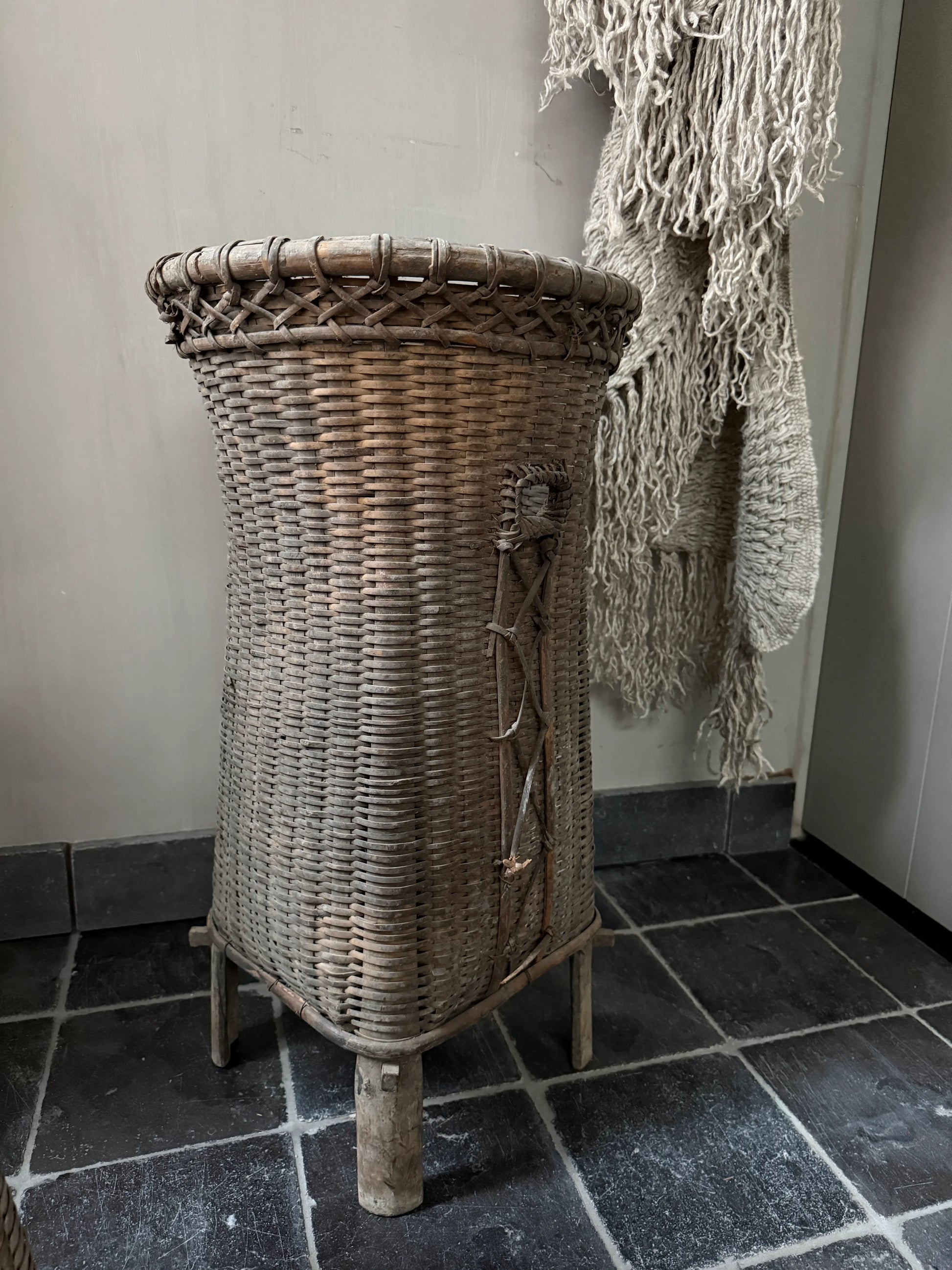 Authentieke hoge rieten mand op houten poten, landelijke woonaccessoire bij My Sober Home