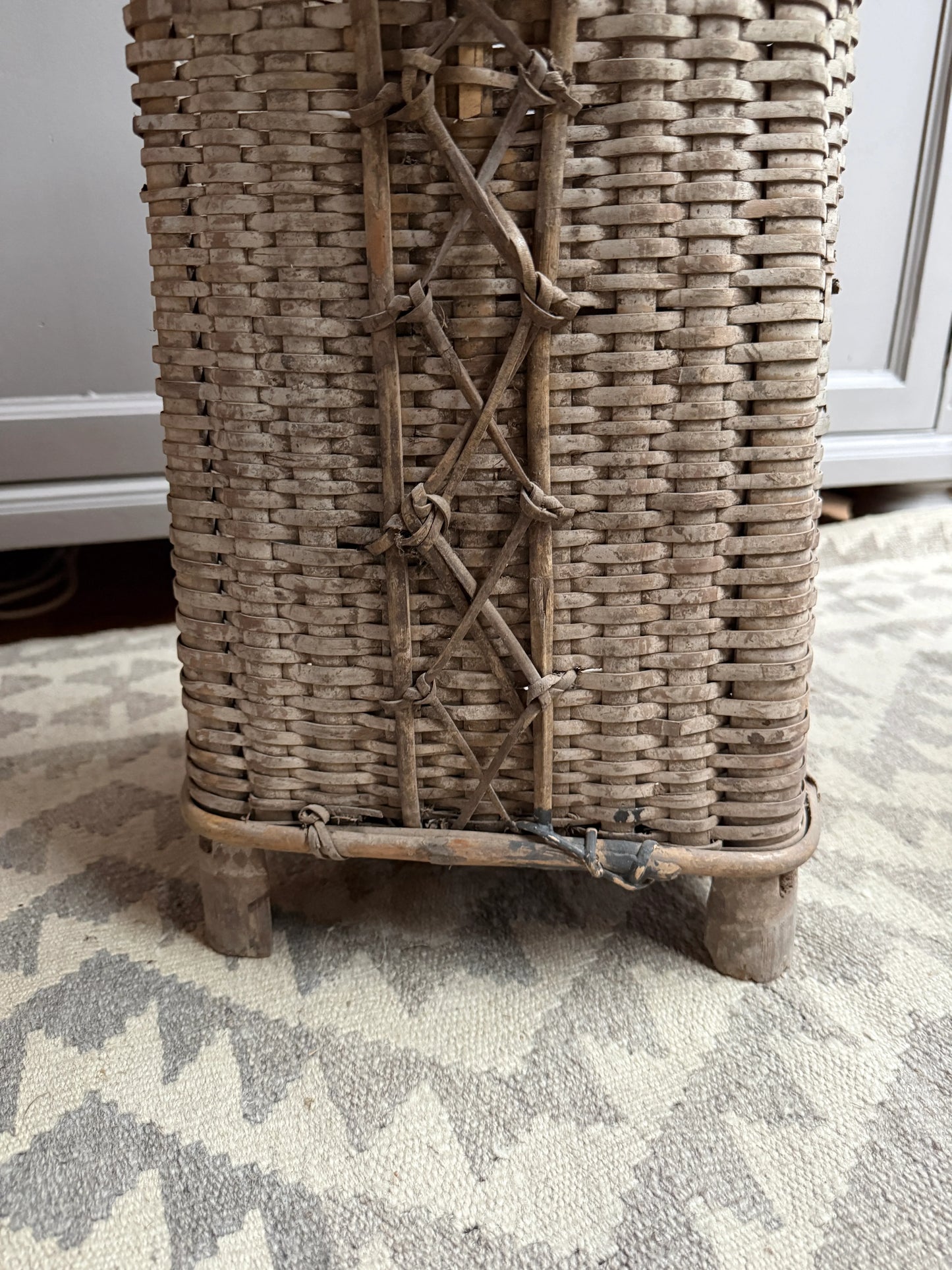 Authentieke handgemaakte rieten mand op houten pootjes, landelijk en sober woonaccessoire