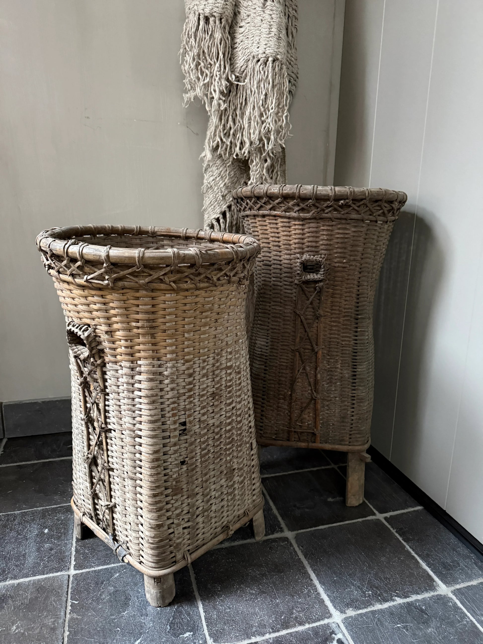 Twee handgemaakte rieten manden in landelijke, sobere interieurstijl op natuurstenen vloer