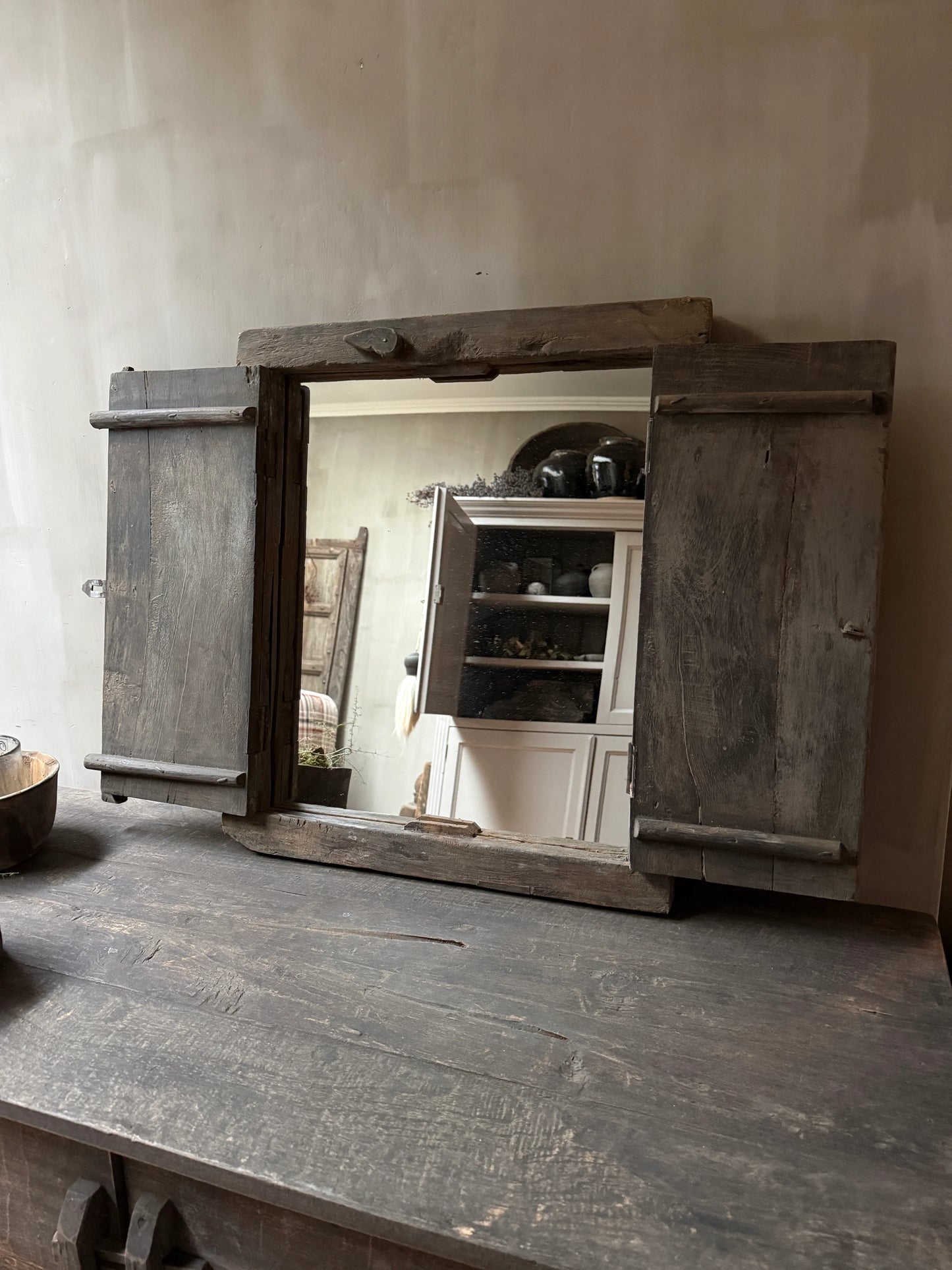 Authentiek houten luikje op een verweerd houten tafel, landelijk en sober interieur