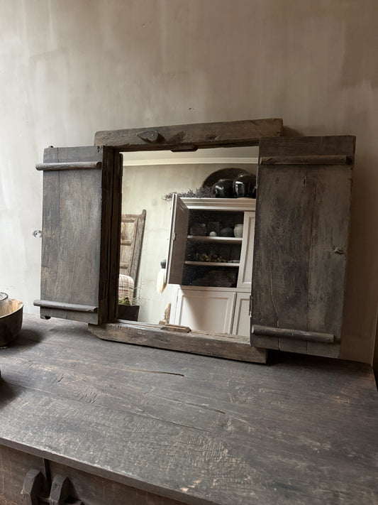 Authentiek houten luikje op een verweerd houten tafel, landelijk en sober interieur