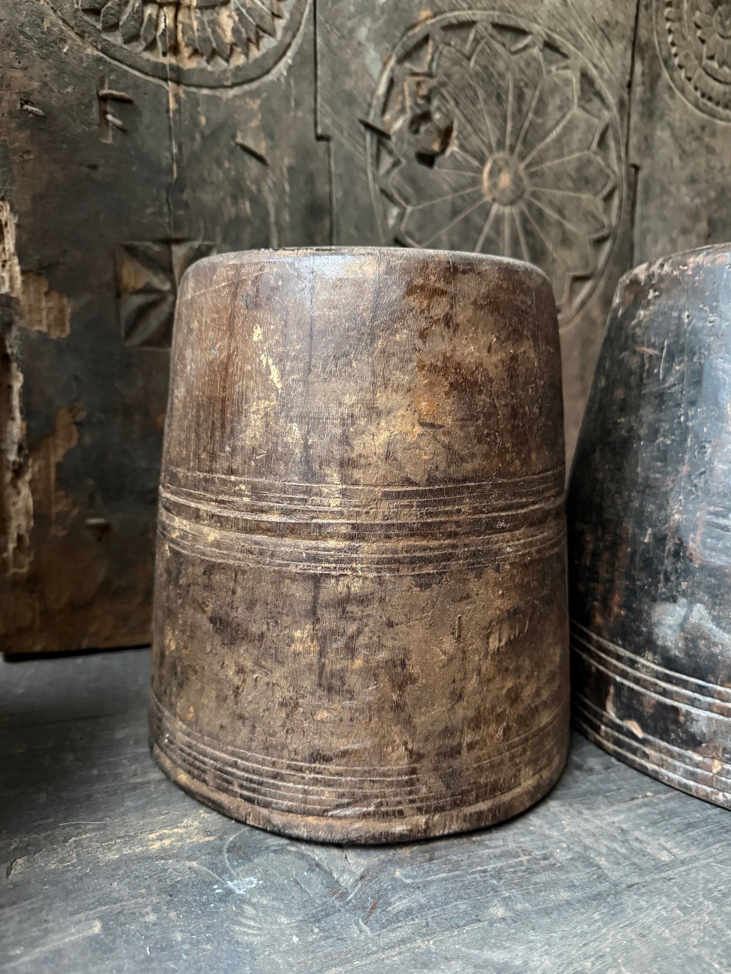 Authentieke houten pot, handgemaakt, met doorleefd karakter op rustieke houten ondergrond.