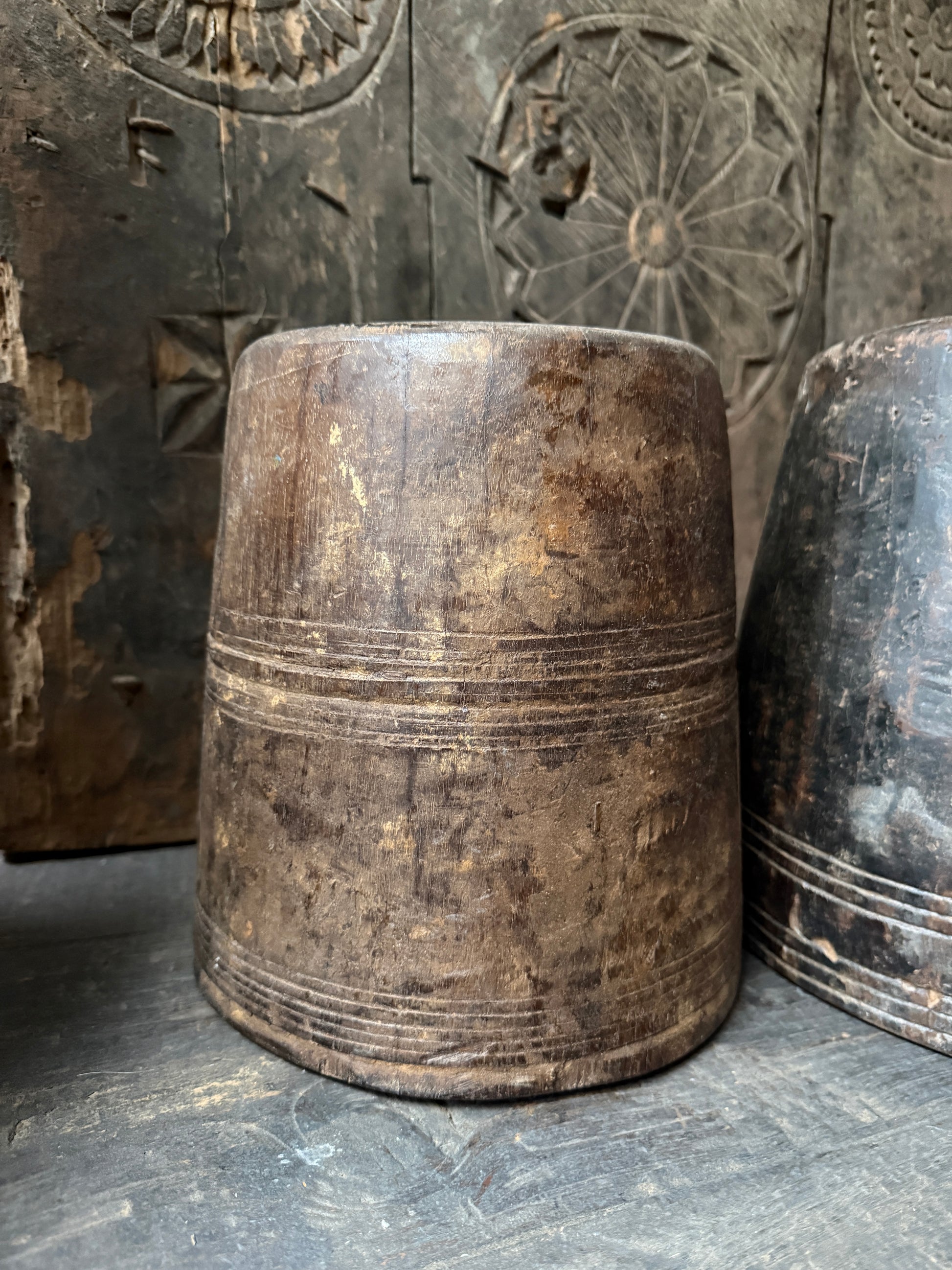 Authentieke houten pot, handgemaakt, met doorleefd karakter op rustieke houten ondergrond.